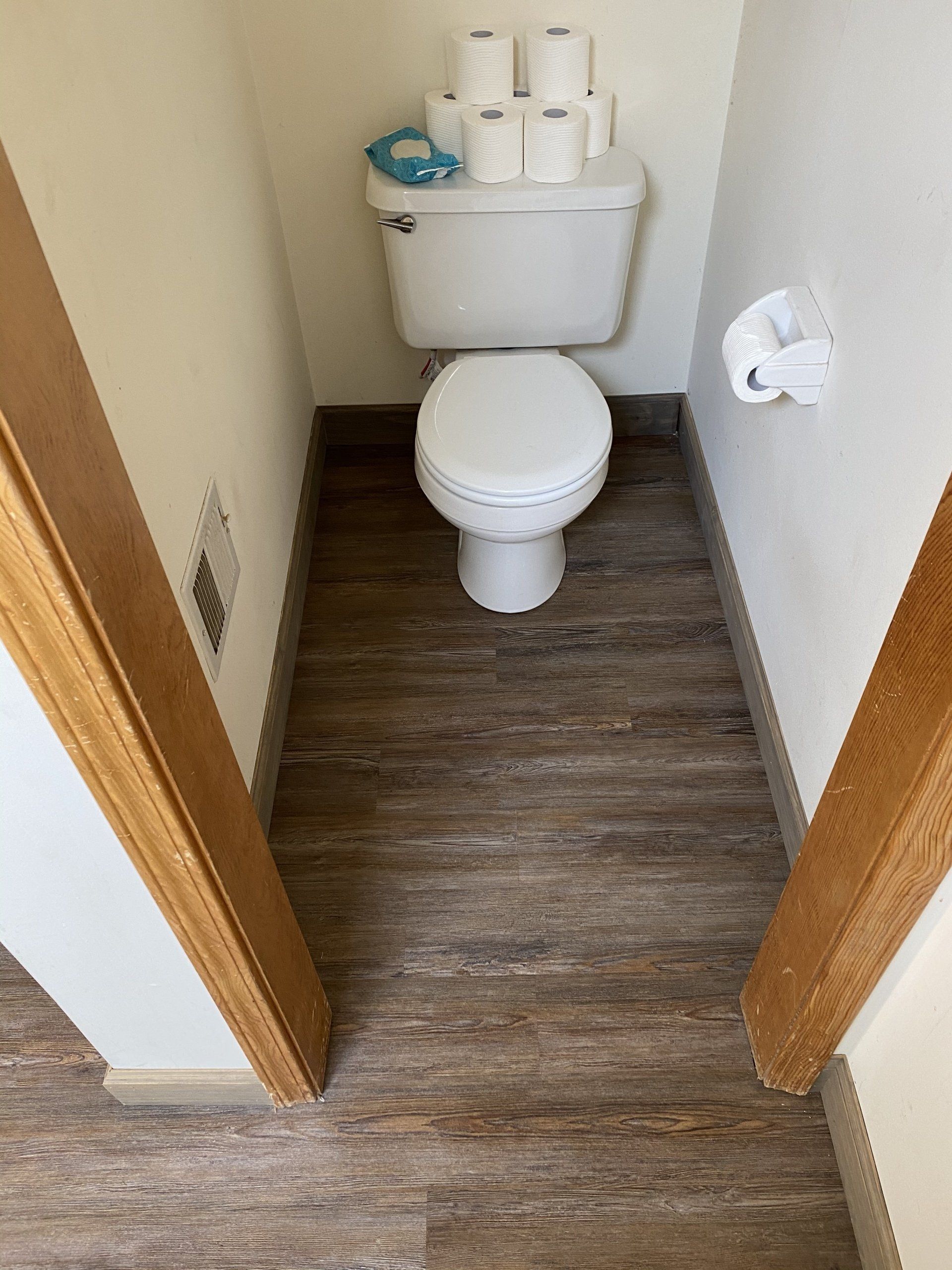 A toilet is sitting in a small bathroom next to a door.
