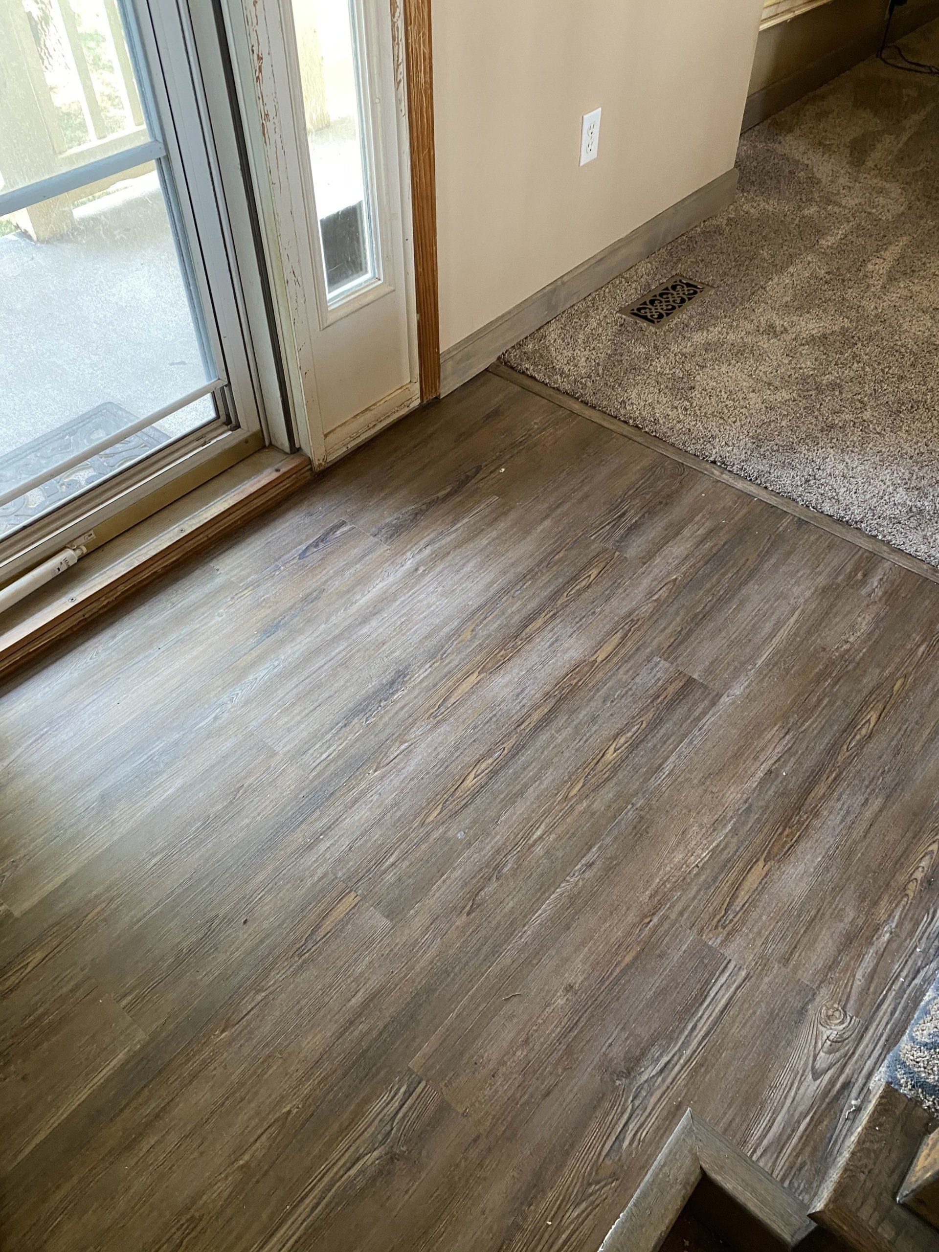 A room with a wooden floor and a sliding glass door.