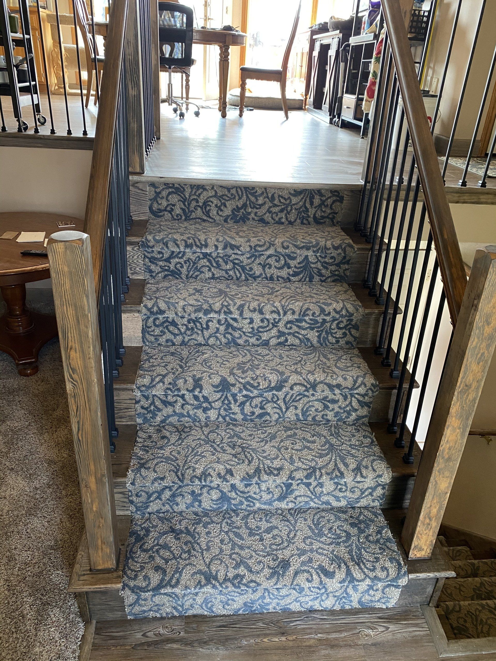 A set of stairs with a carpet on them and a railing.