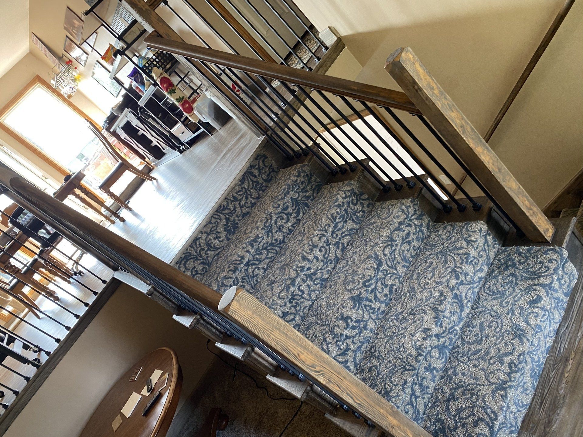 A staircase with a blue carpet and a wooden railing in a house.