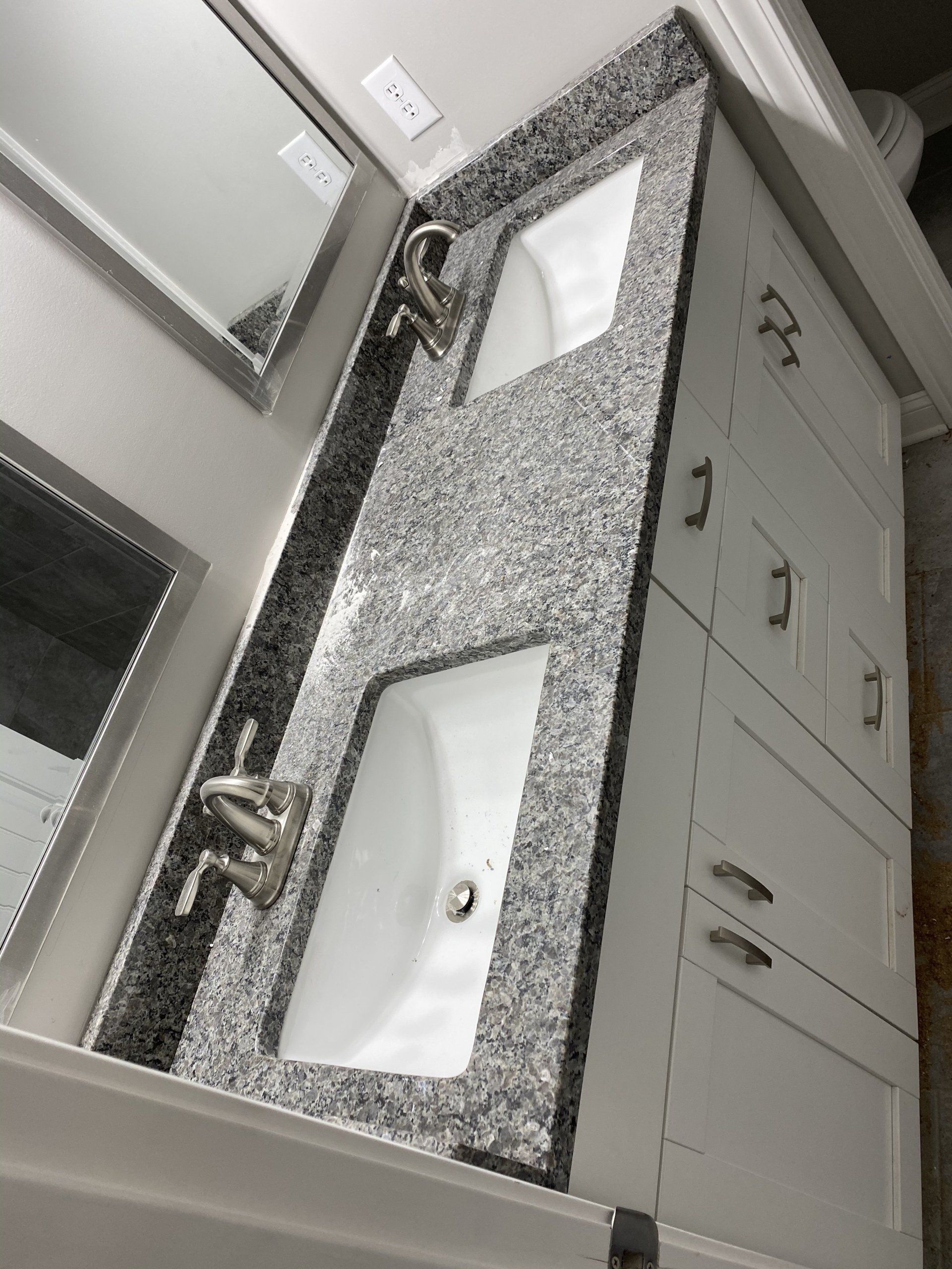A bathroom vanity with two sinks and a mirror.