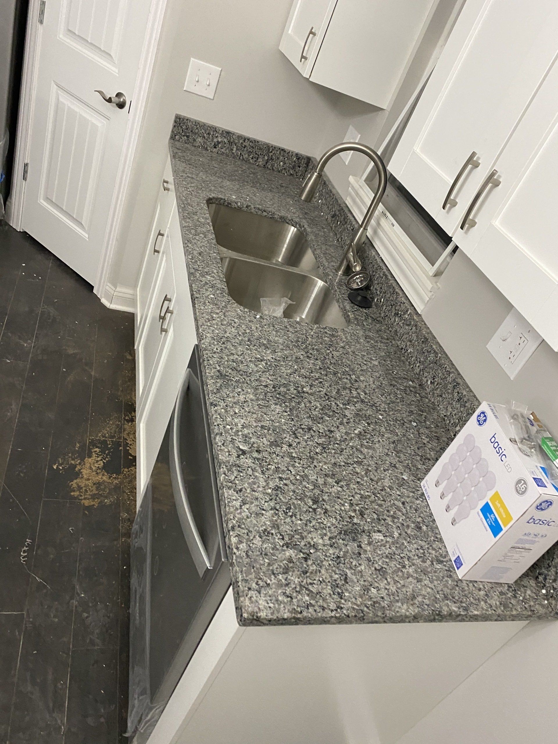 A kitchen with granite counter tops and a stainless steel sink