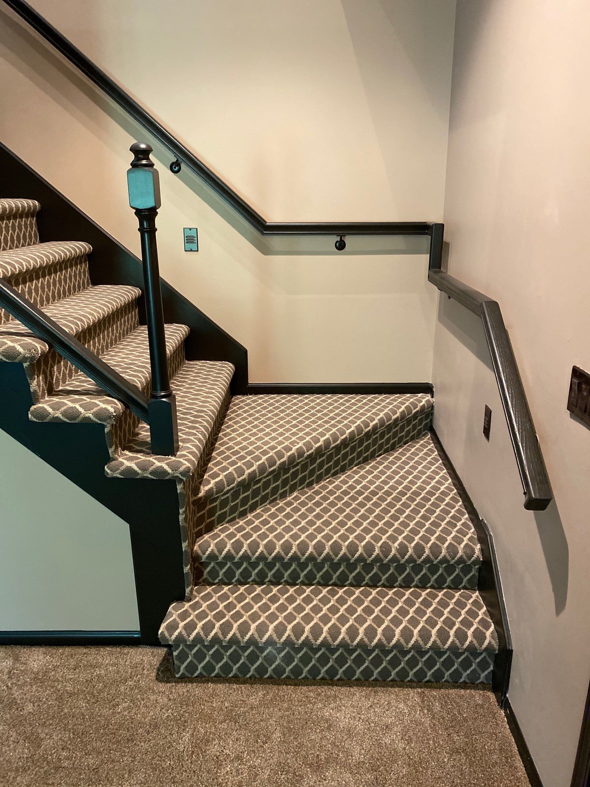 A staircase with carpeted steps and a black railing