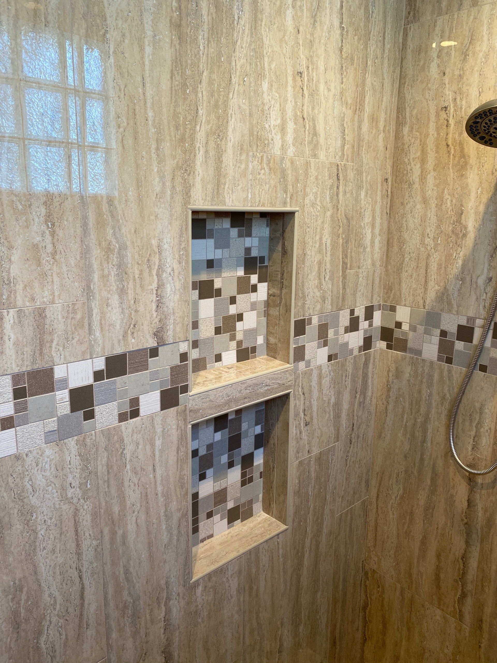 A shower with two niches and a shower head.