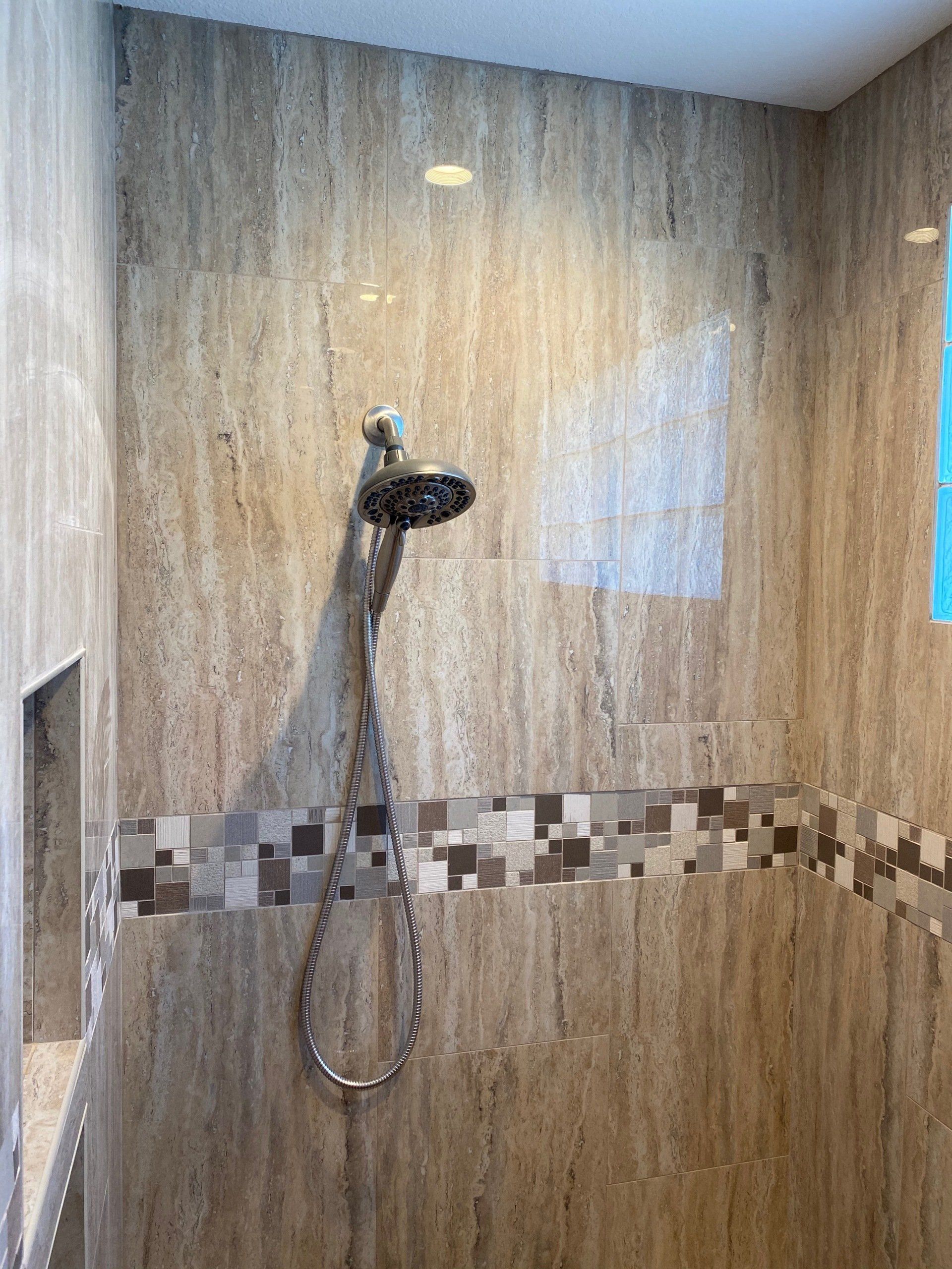 A shower with a shower head and a hose in a bathroom.