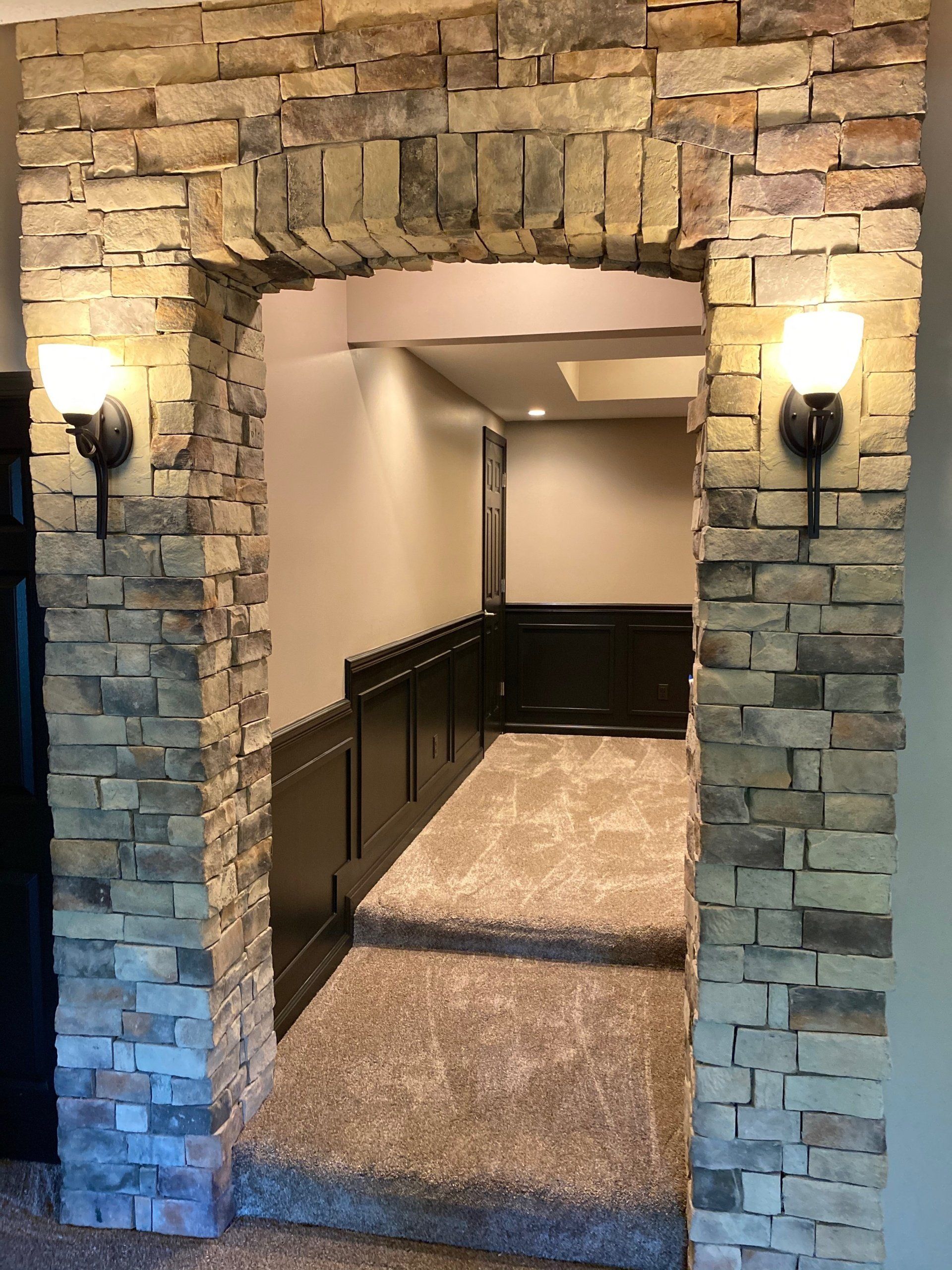 A room with a brick wall and stairs leading to it.