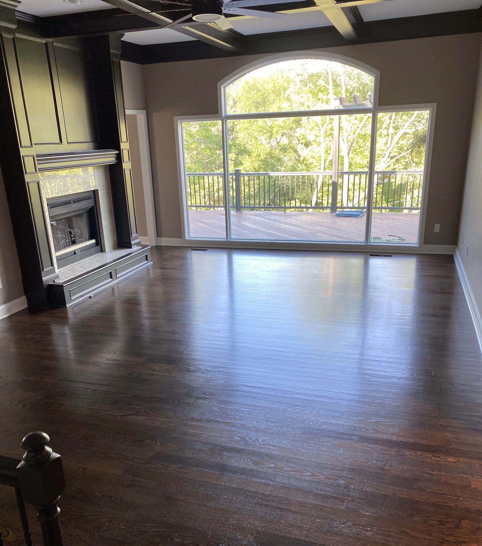An empty living room with a fireplace and sliding glass doors.