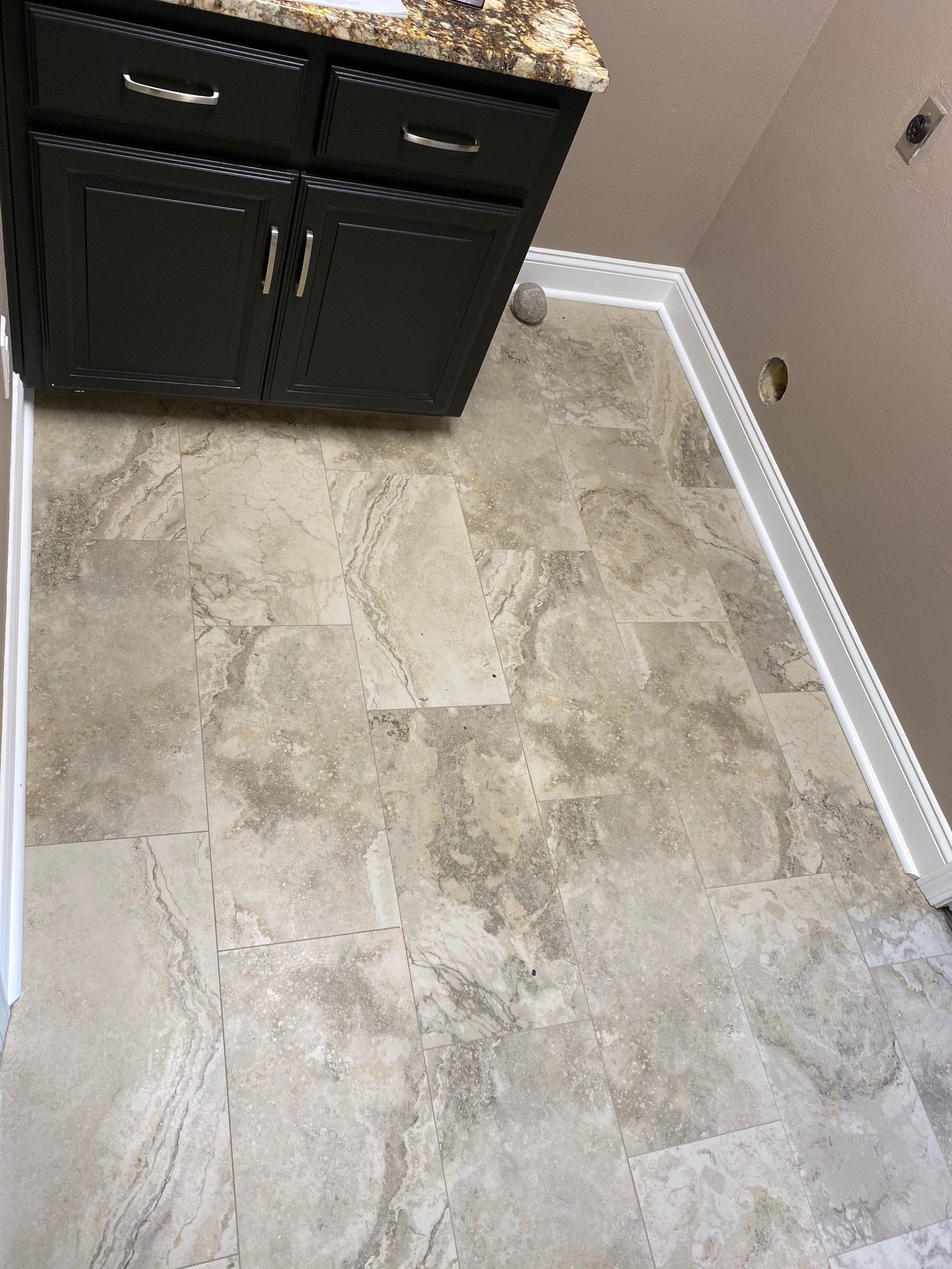 A bathroom with a tiled floor and a sink.