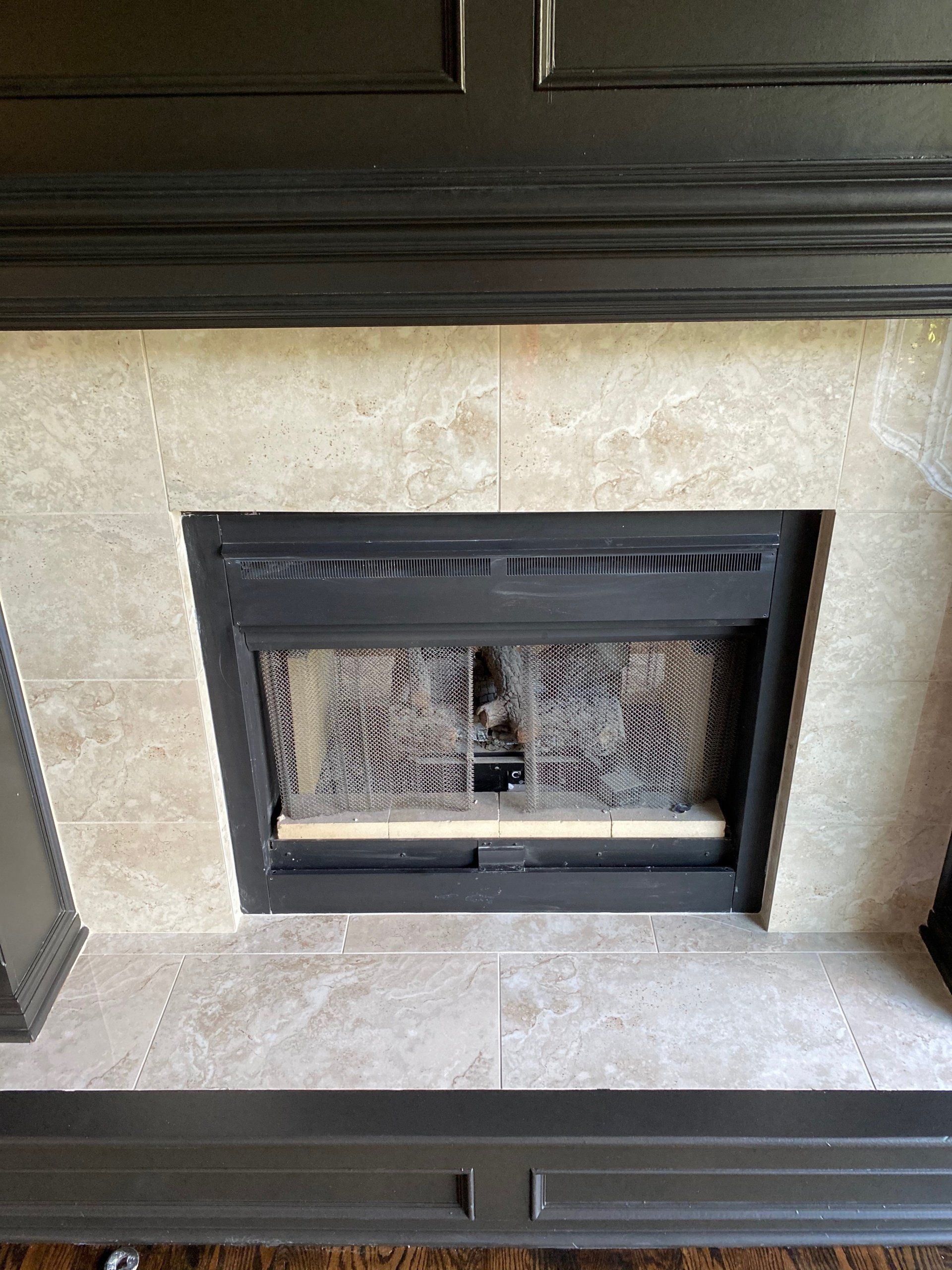 A fireplace with a black mantle and a black door