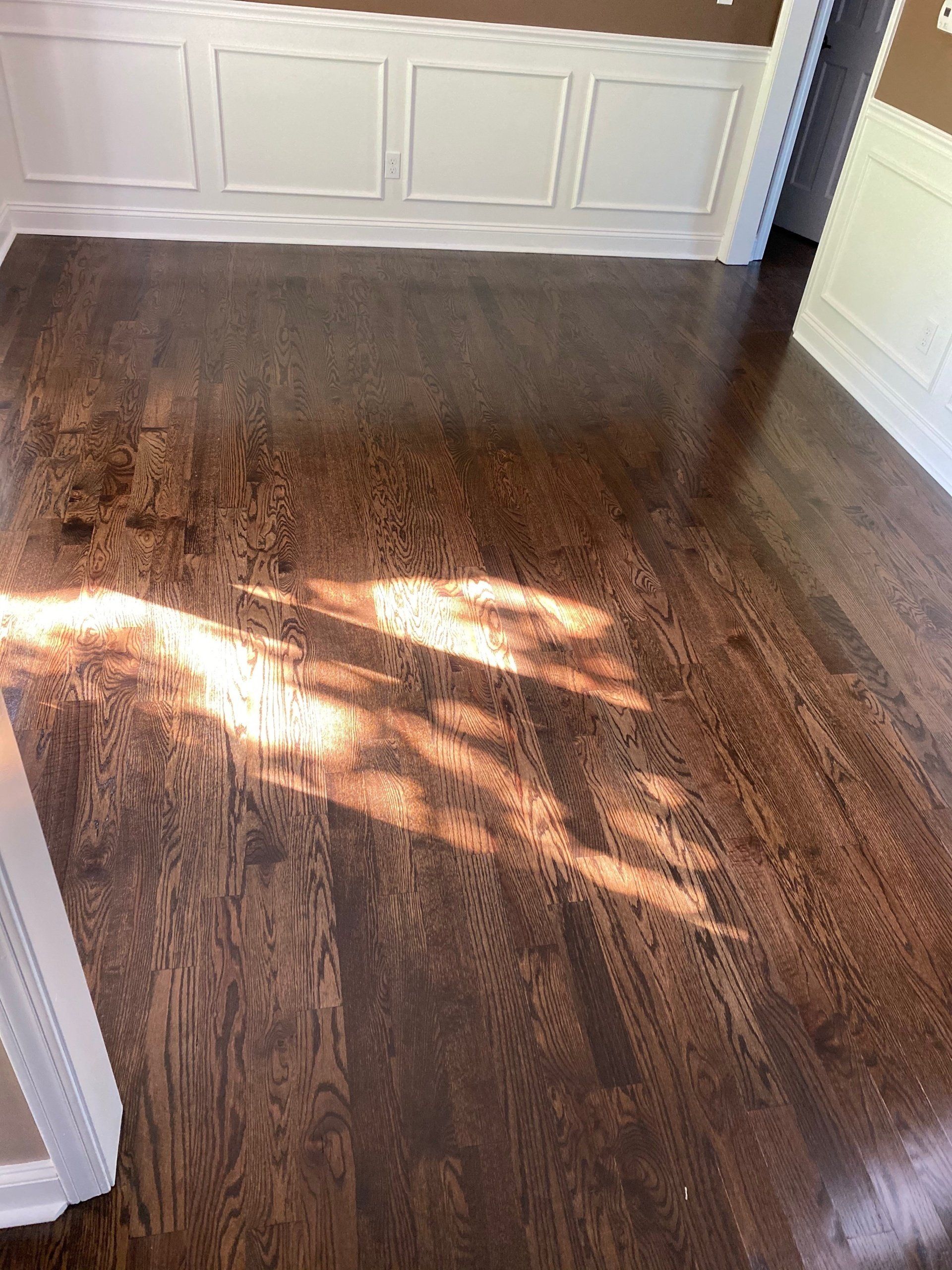 A room with a wooden floor and a white wall.