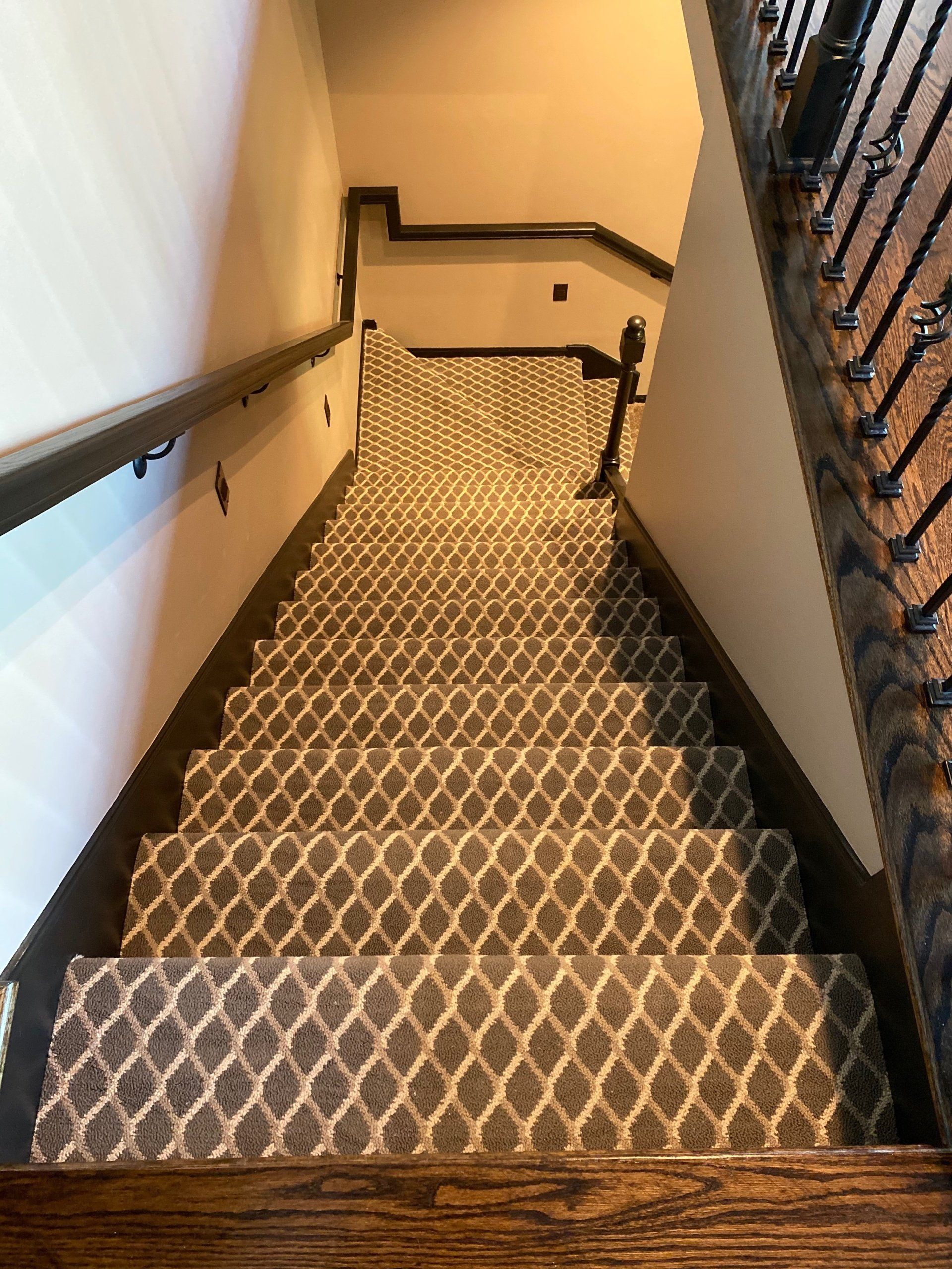 A staircase with a patterned carpet and a wooden railing.