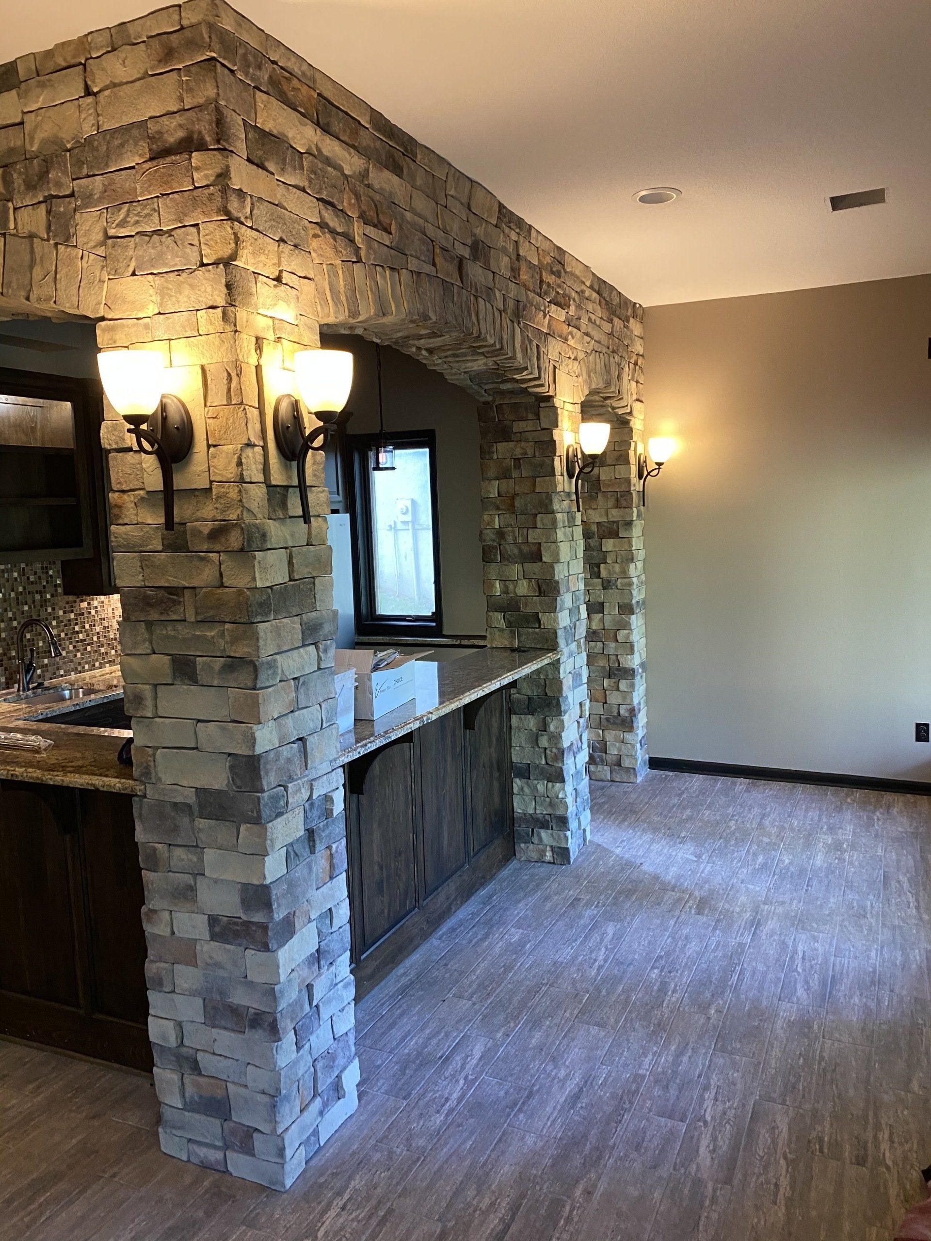 A kitchen with a stone wall and a counter top.