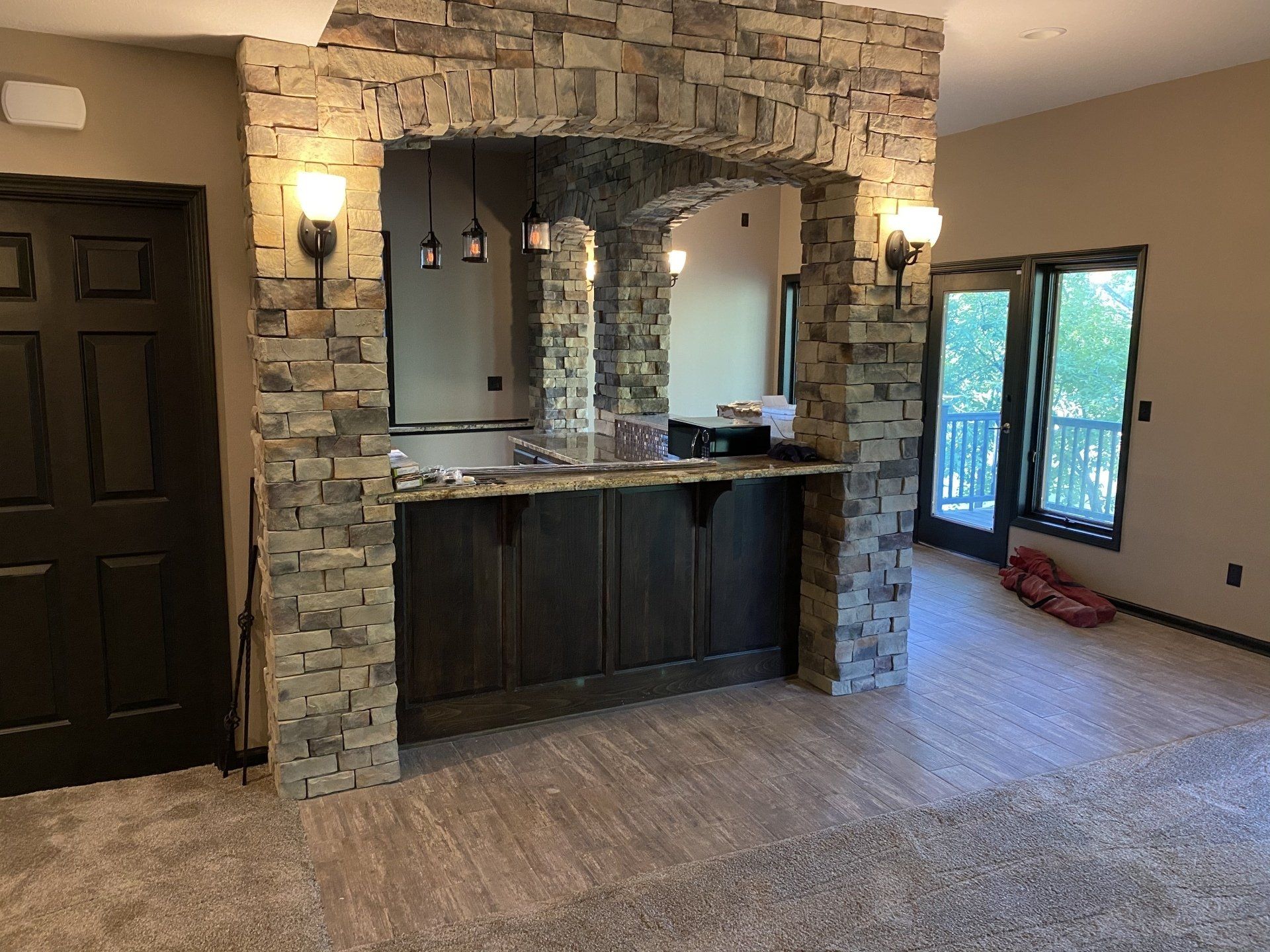 A living room with a stone wall and a bar