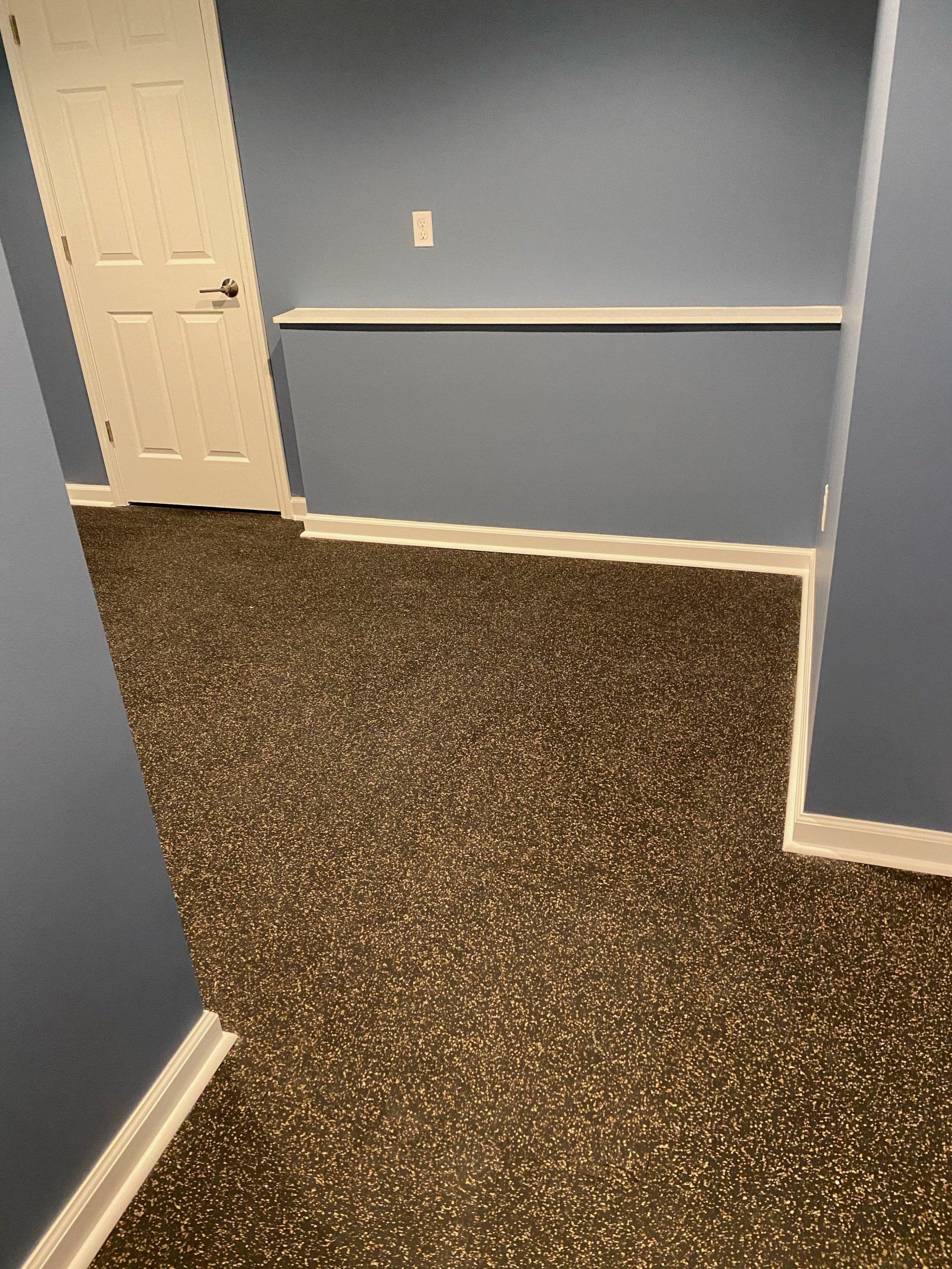 A room with a brown carpet and blue walls.