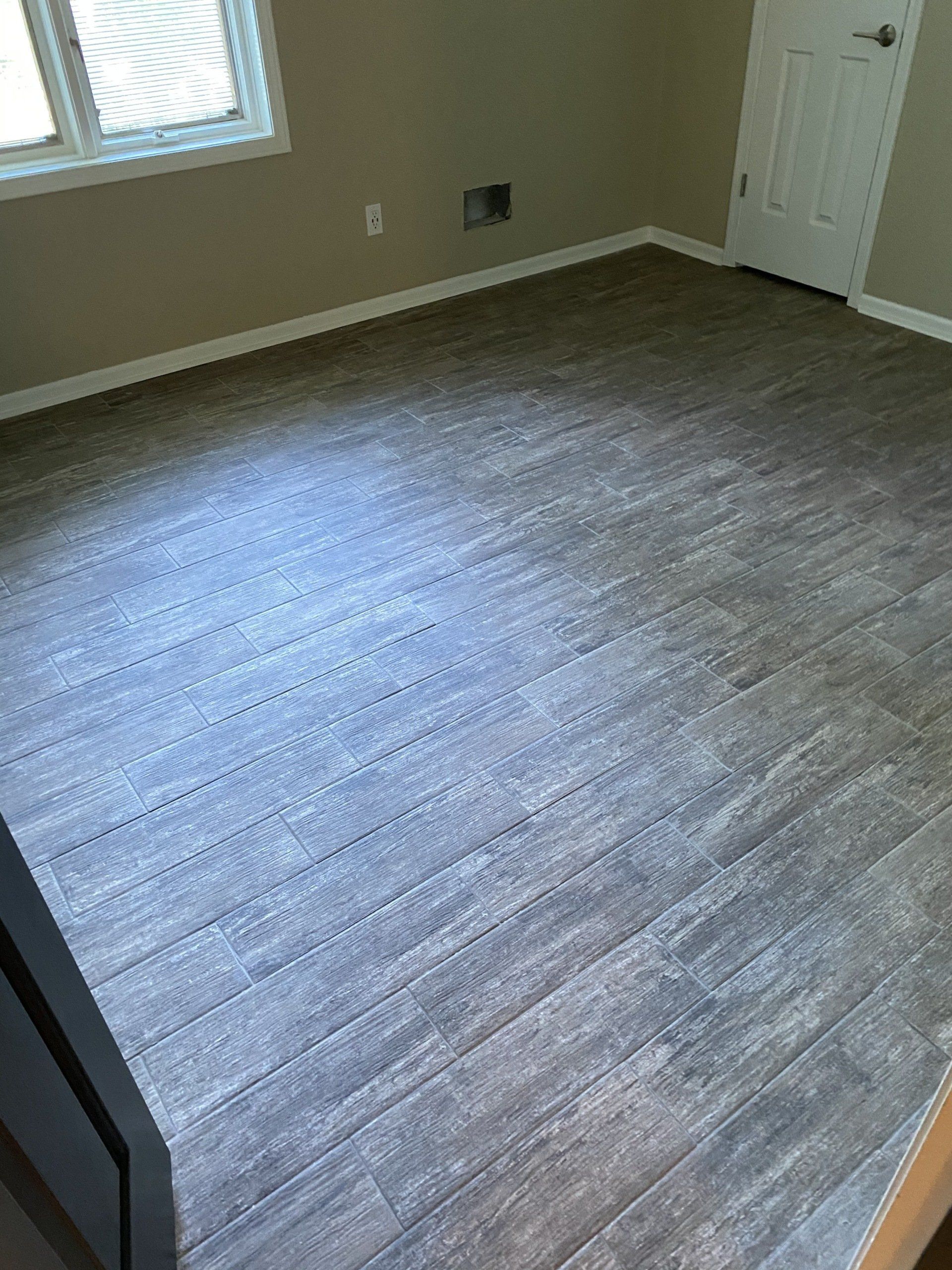 A room with a wooden floor and a window.