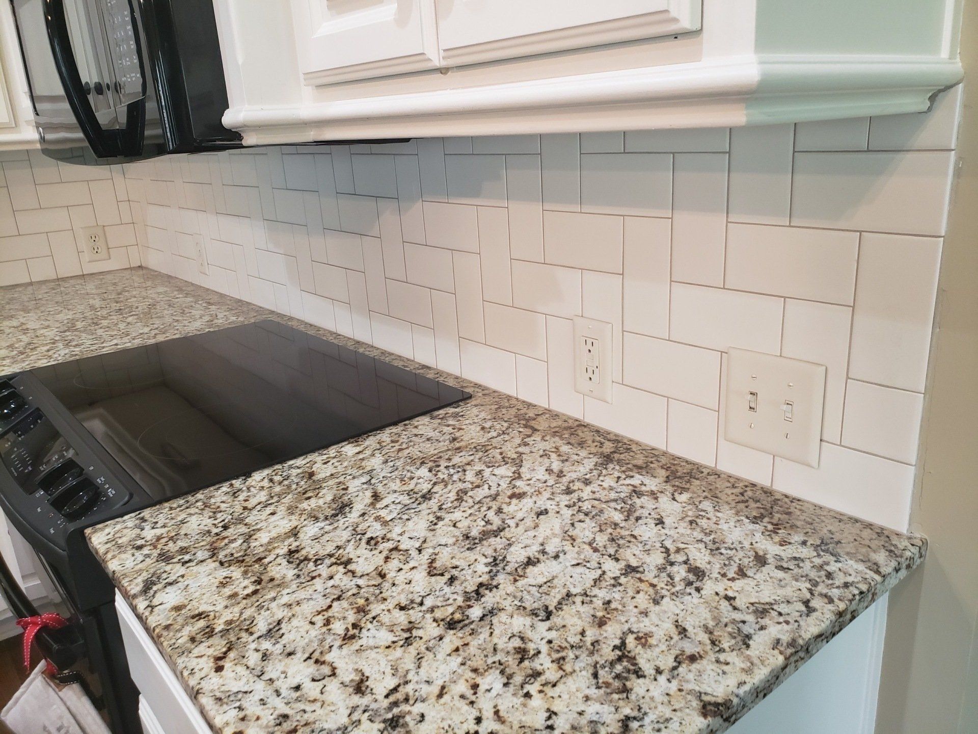 A kitchen with granite counter tops and a stove top oven.