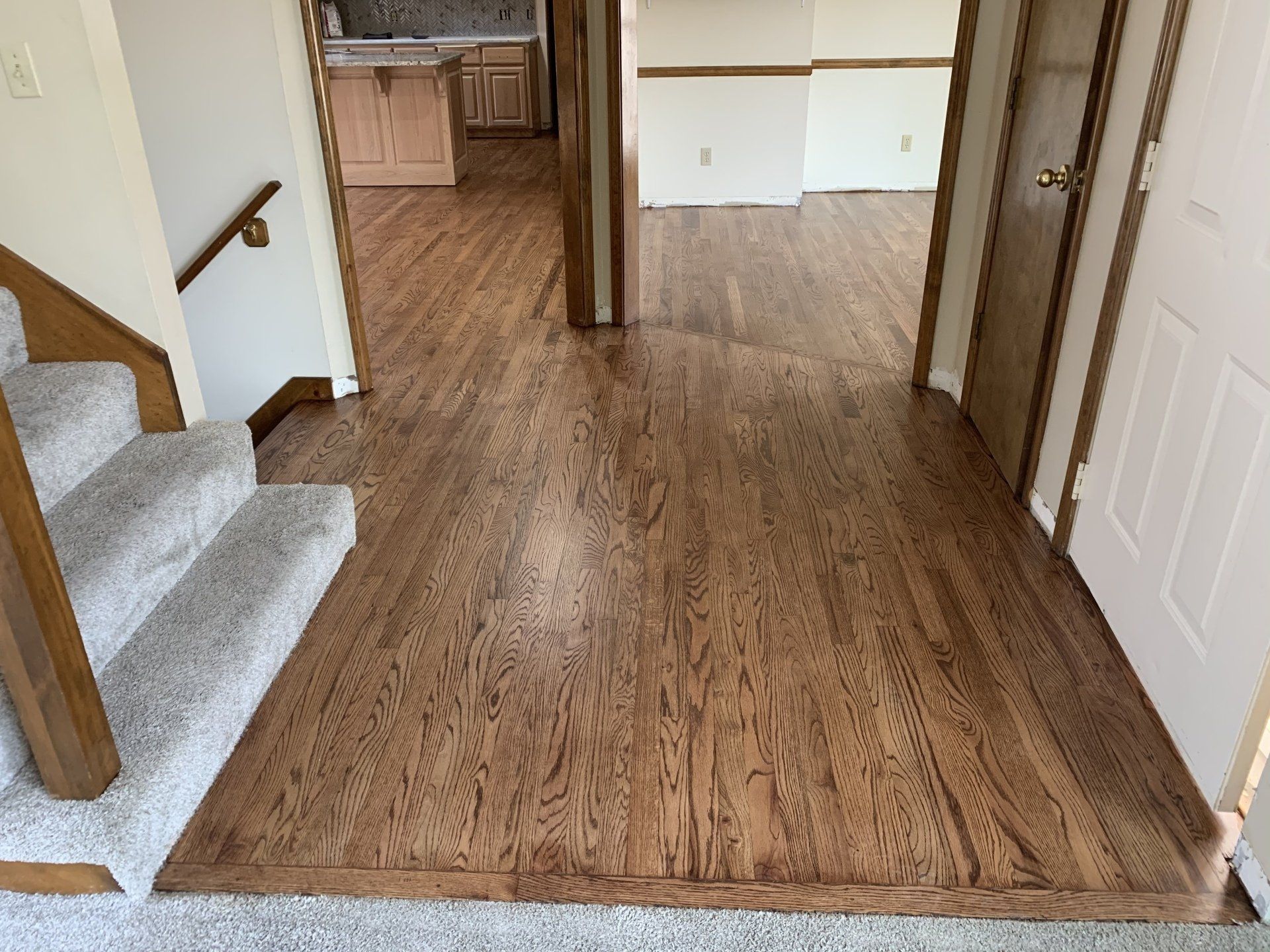 A hallway with hardwood floors and stairs in a house