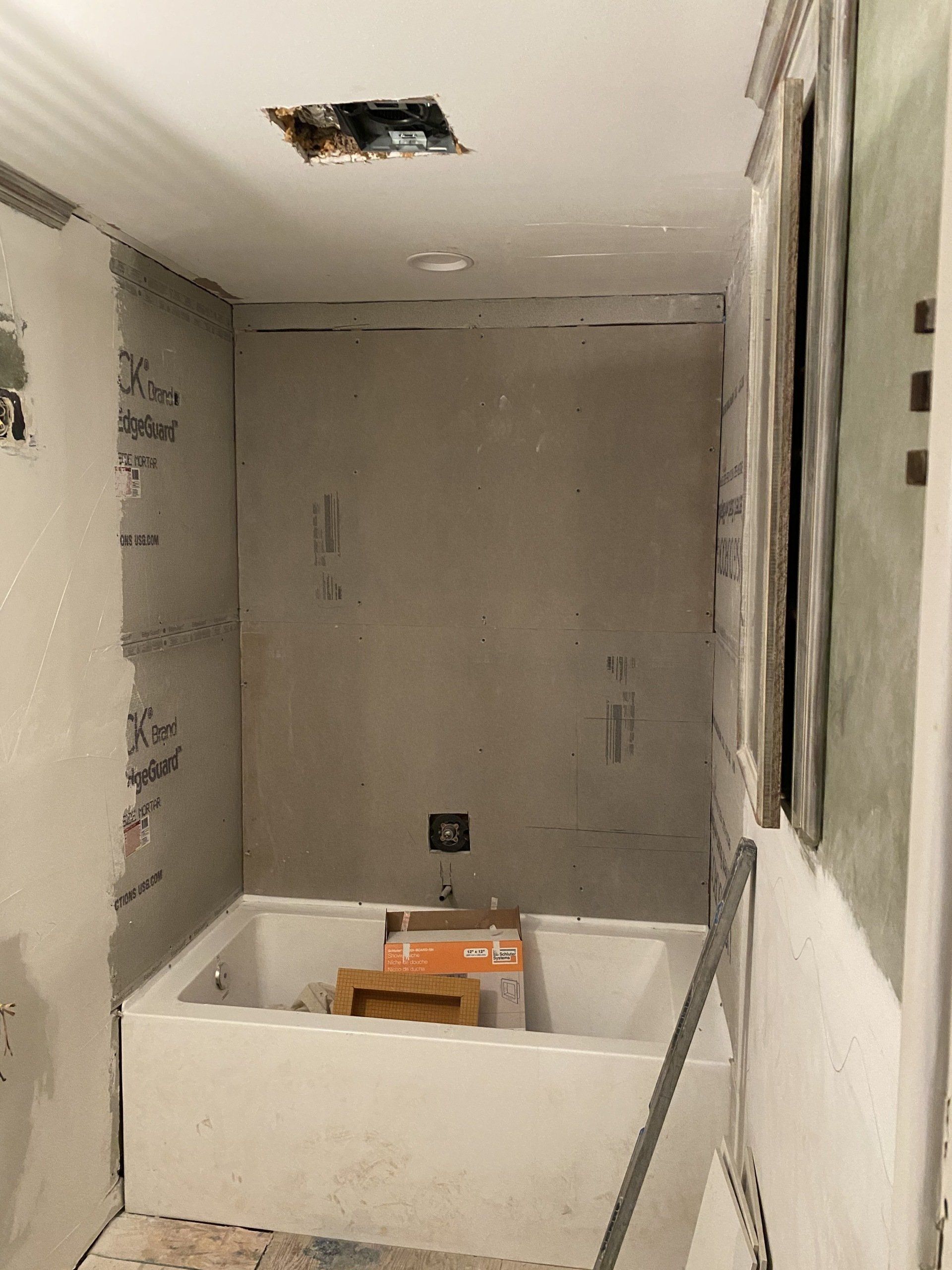 A bathroom under construction with a bathtub and a shower.