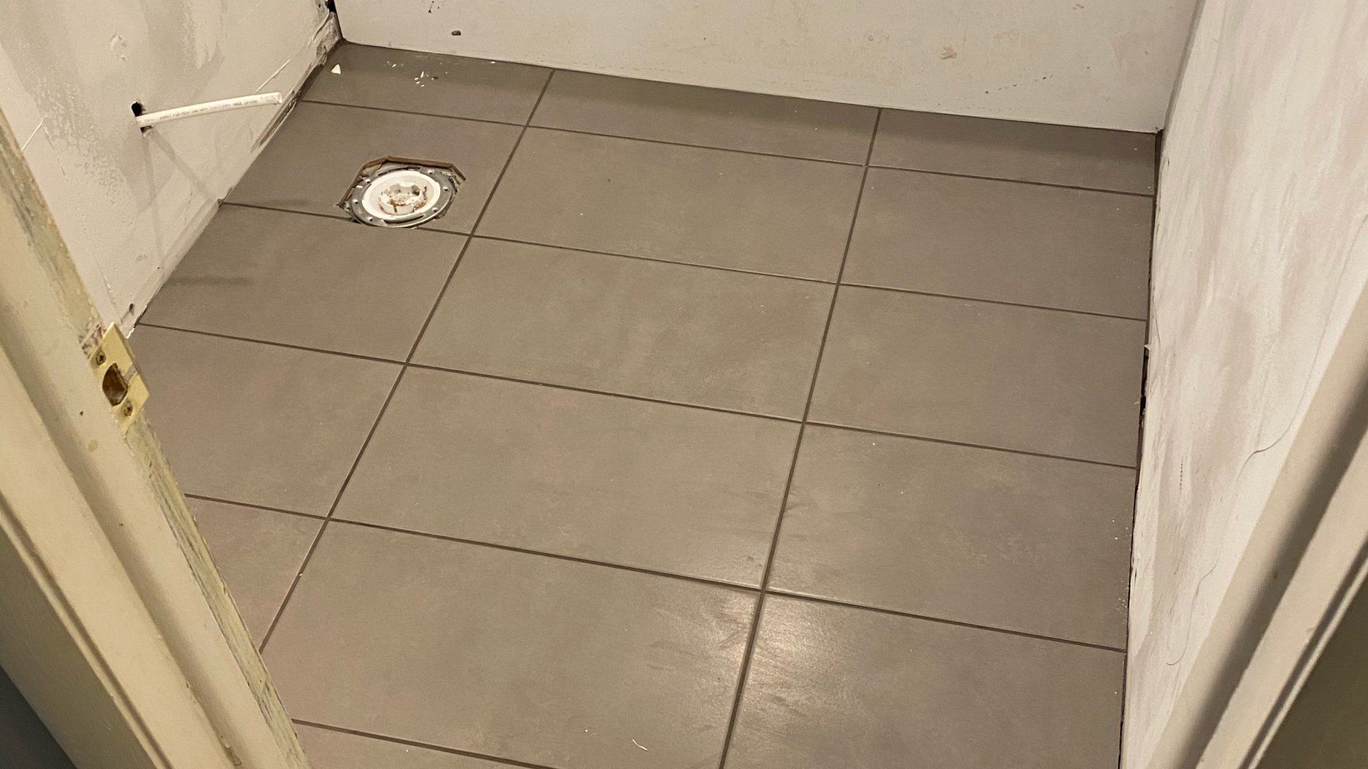 A bathroom with a tiled floor and a shower curtain.