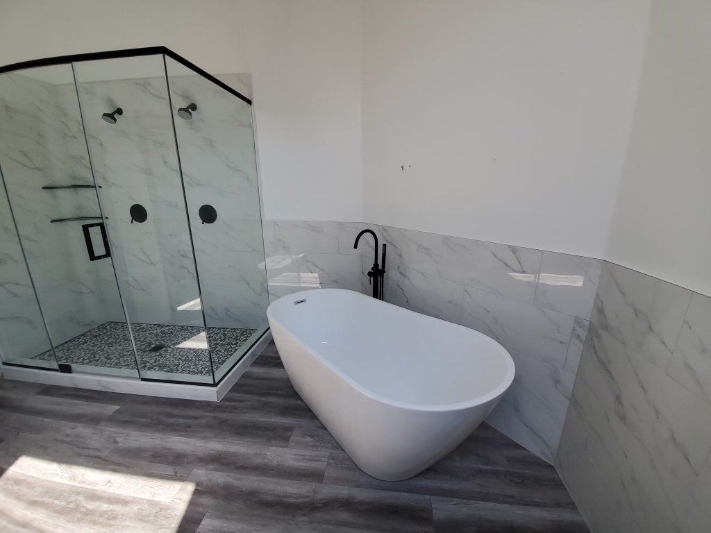 A bathroom with a bathtub and a shower stall.
