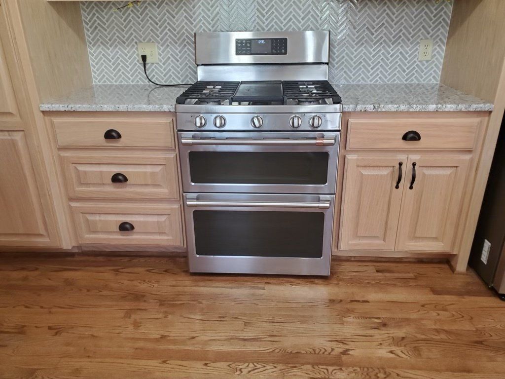 A stainless steel stove and oven in a kitchen with wooden cabinets.