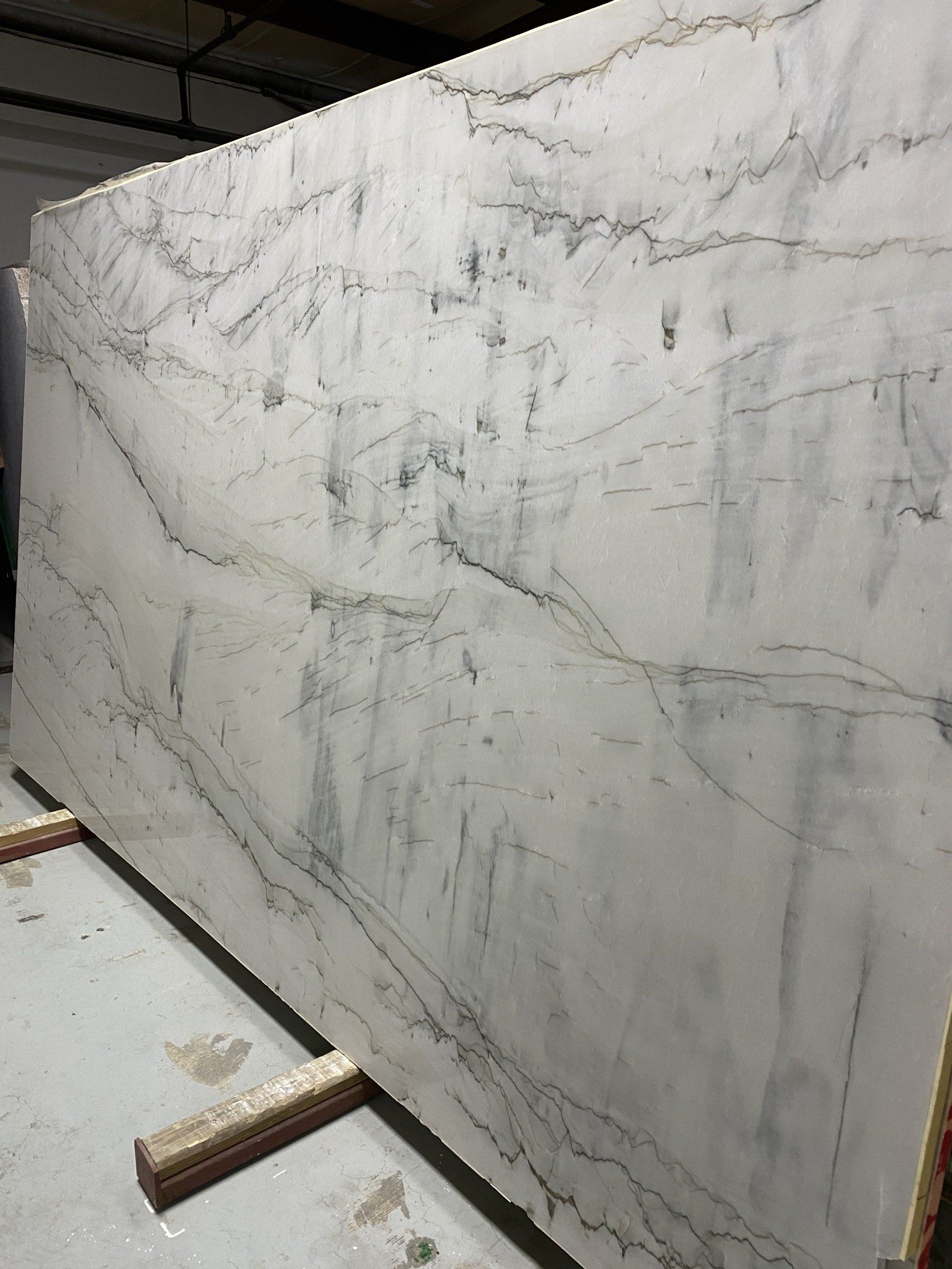A large white marble slab is sitting on a wooden pallet.