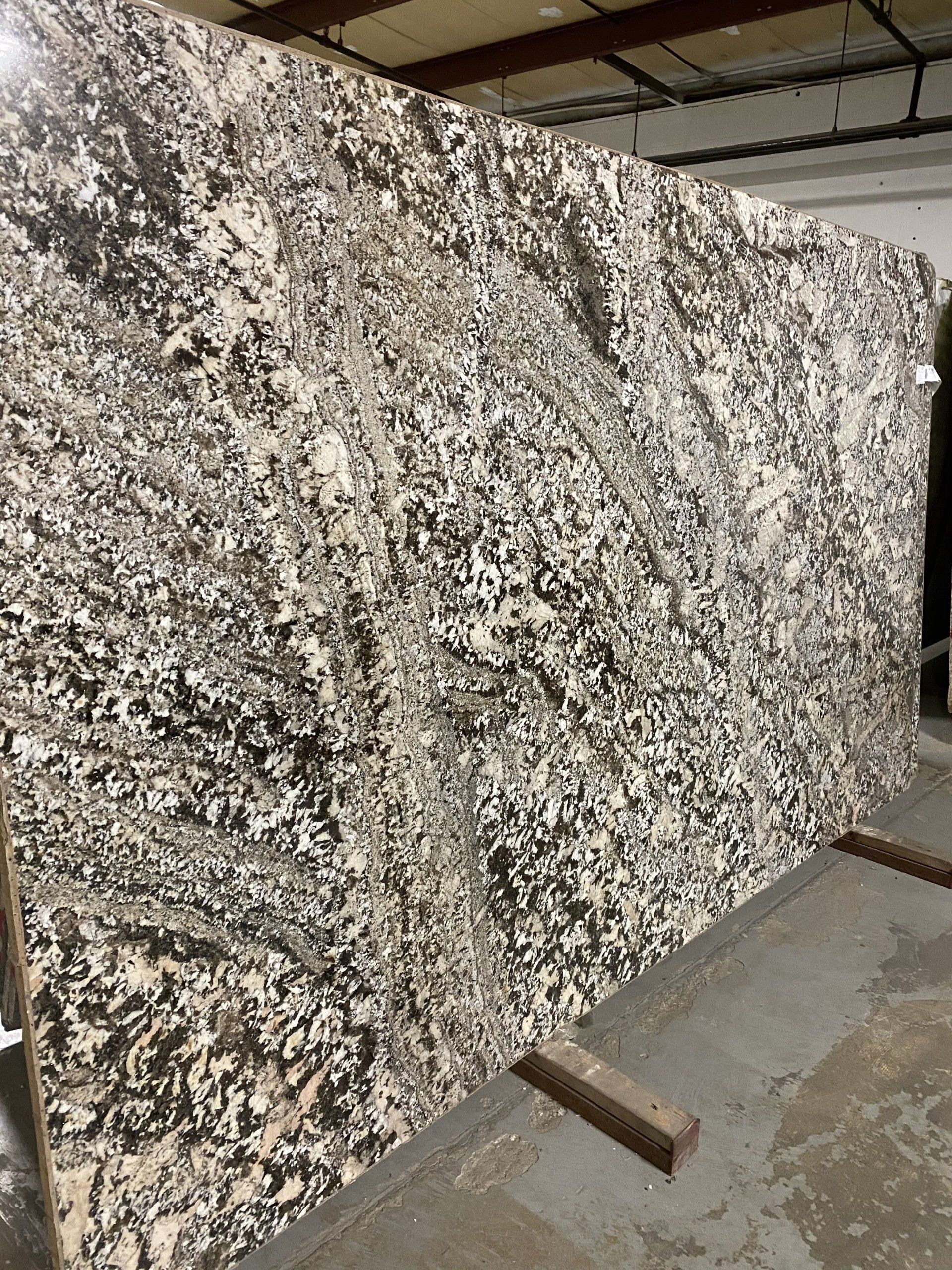 A large slab of granite is sitting on top of a concrete floor in a warehouse.