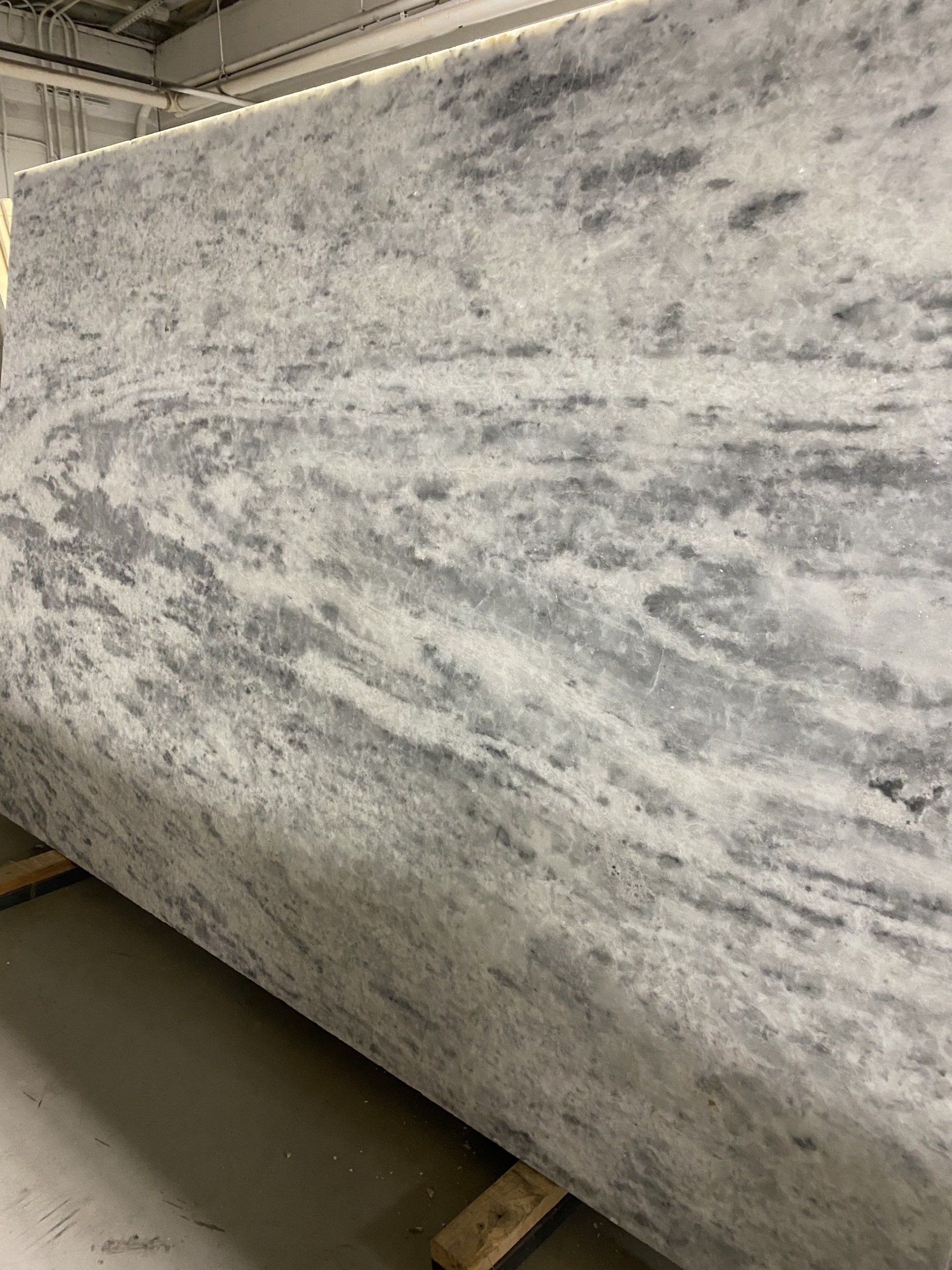 A large slab of white granite is sitting on top of a wooden pallet.