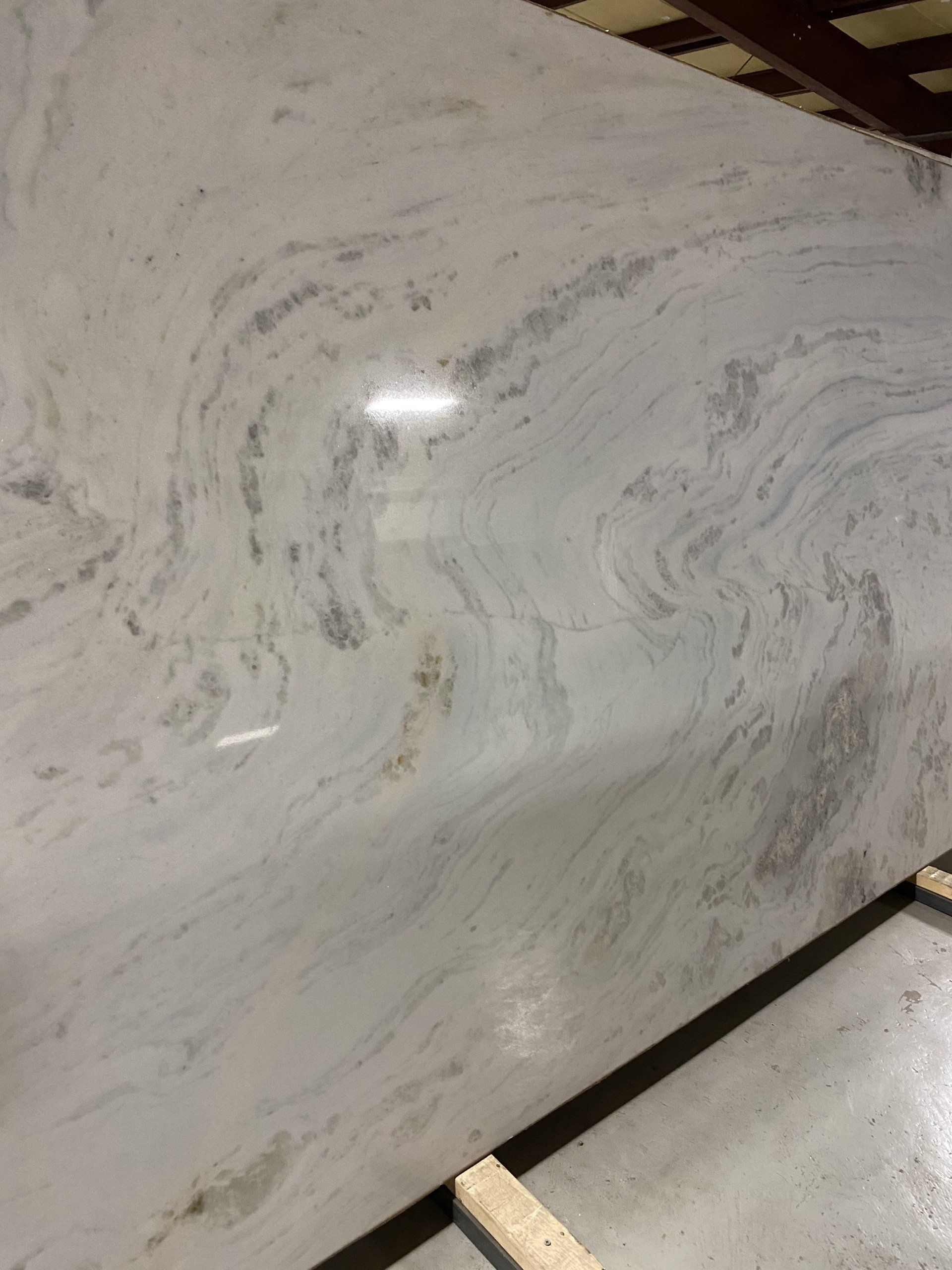 A large white marble slab is sitting on top of a wooden pallet.