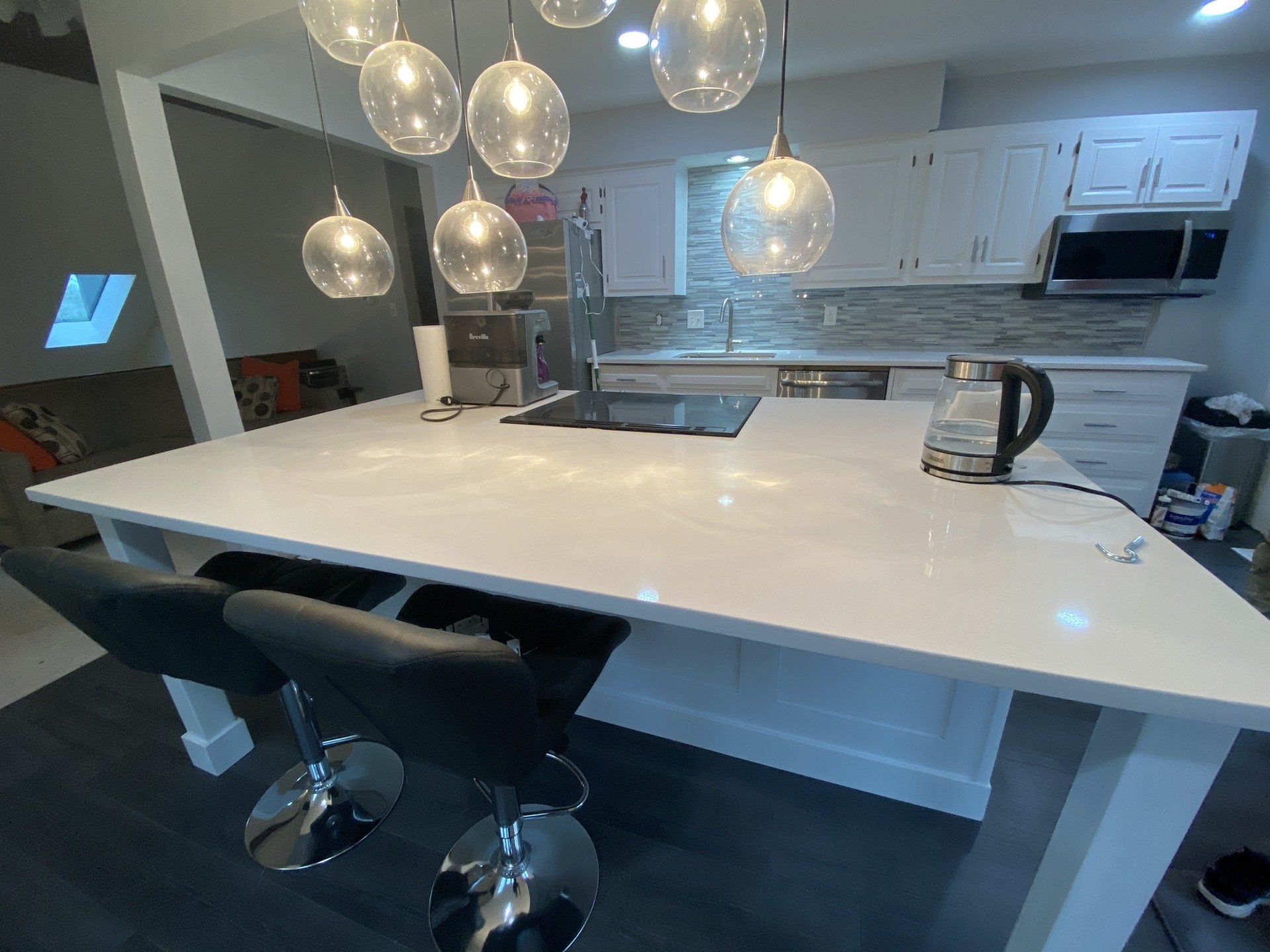 A kitchen with a large island and stools.