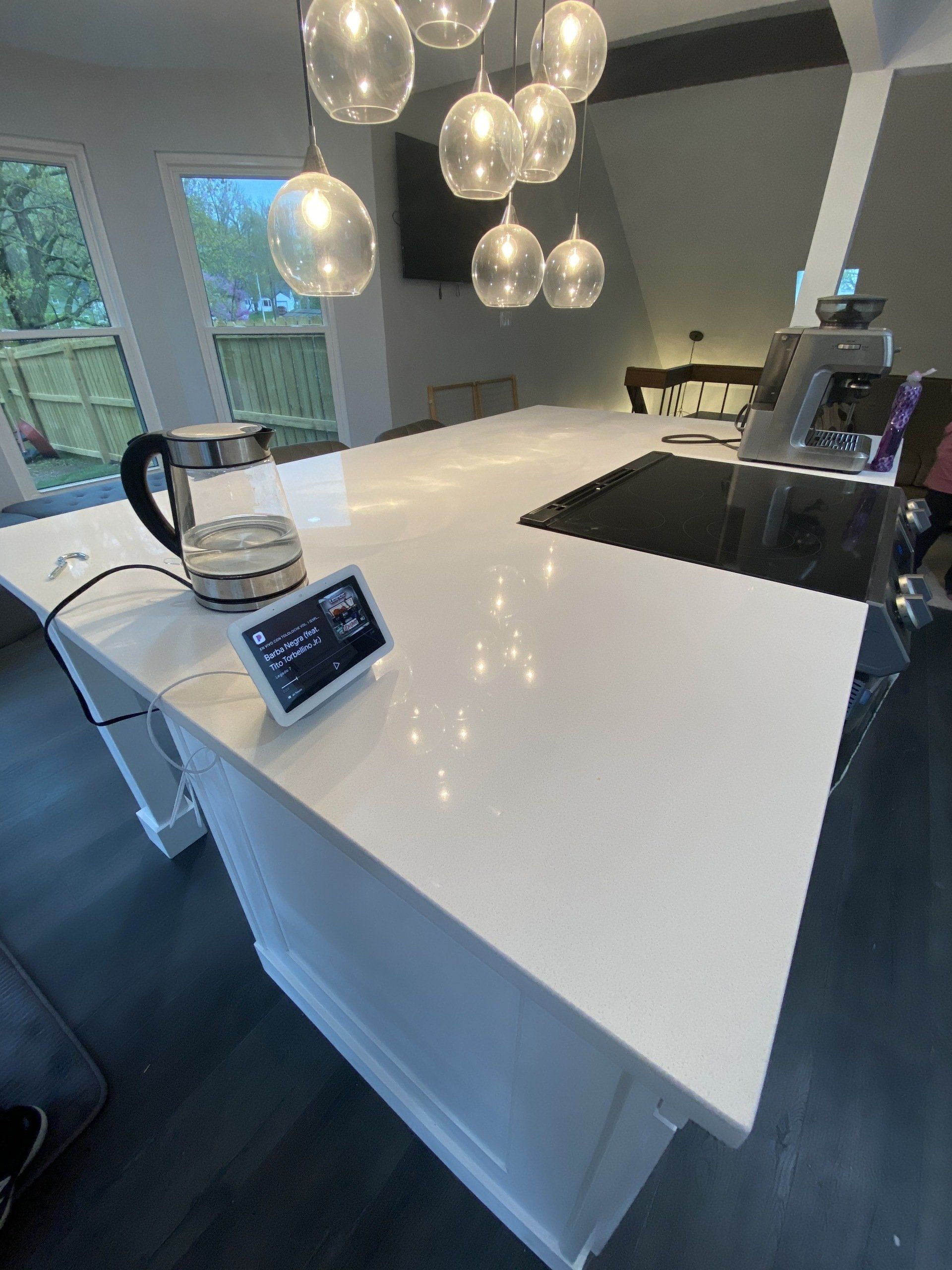 A kitchen with a white counter top and a clock on it.