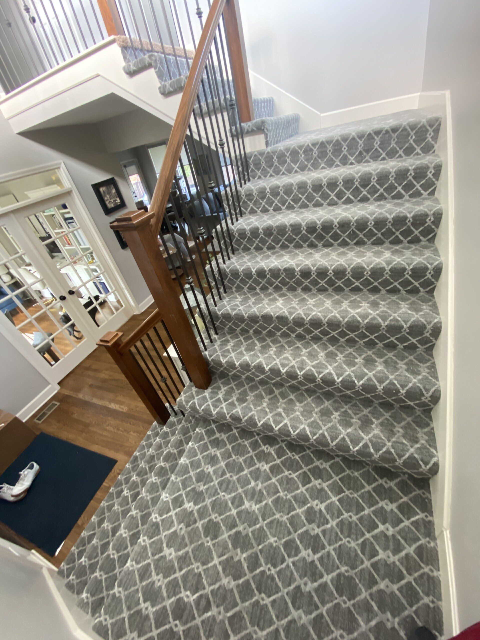 A staircase with a patterned carpet and a wooden railing.