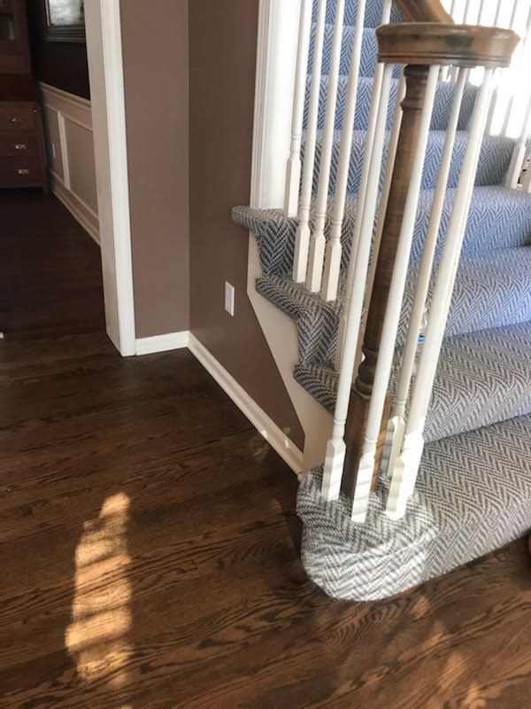 A staircase with a carpeted staircase and a wooden railing.
