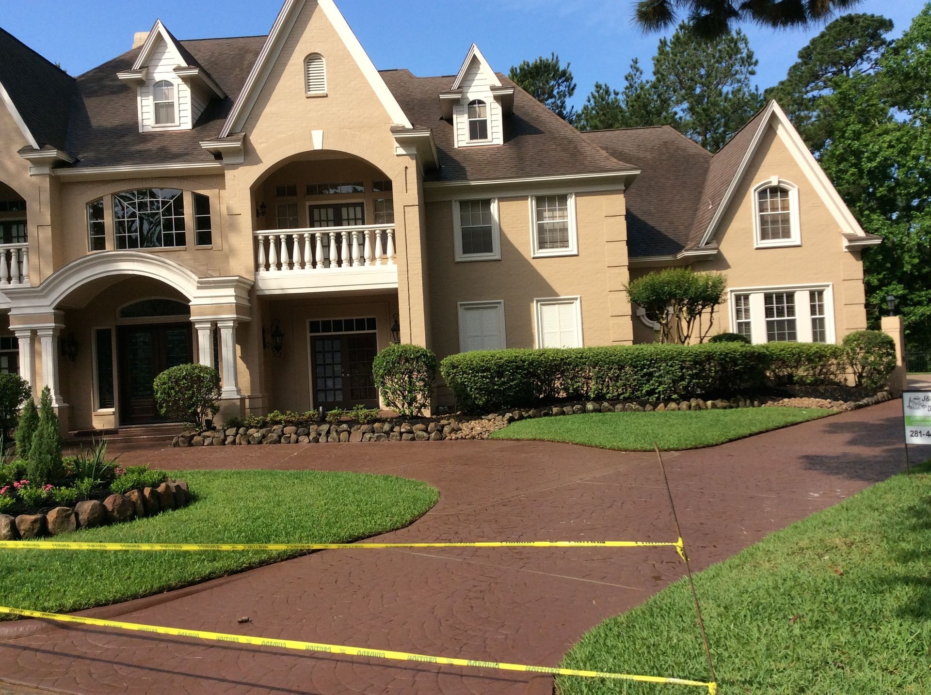 A large house with a red driveway and a sign in front of it