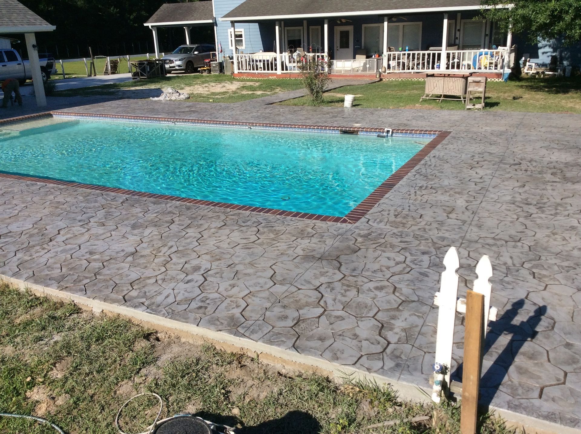 A large swimming pool in front of a house