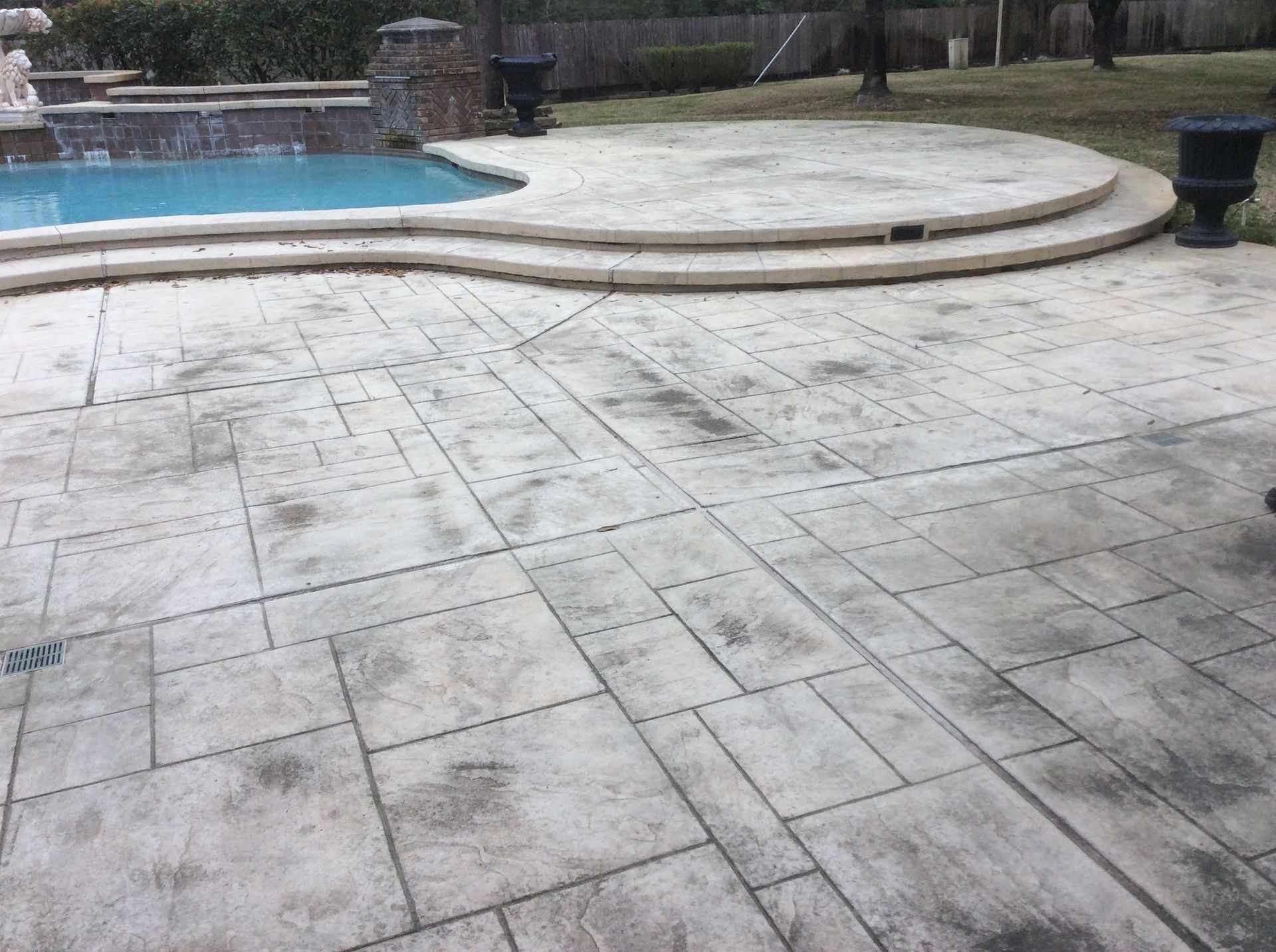 A patio with a swimming pool in the background.