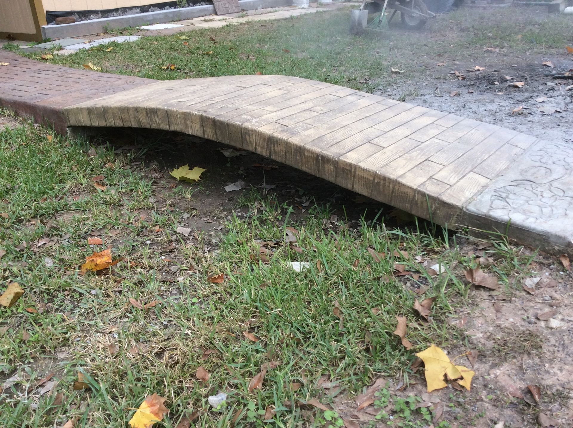 A brick walkway is sitting on top of a lush green field.