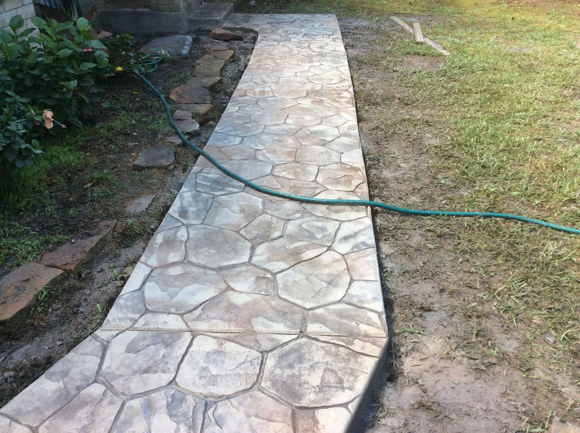 A concrete walkway with a hose attached to it.