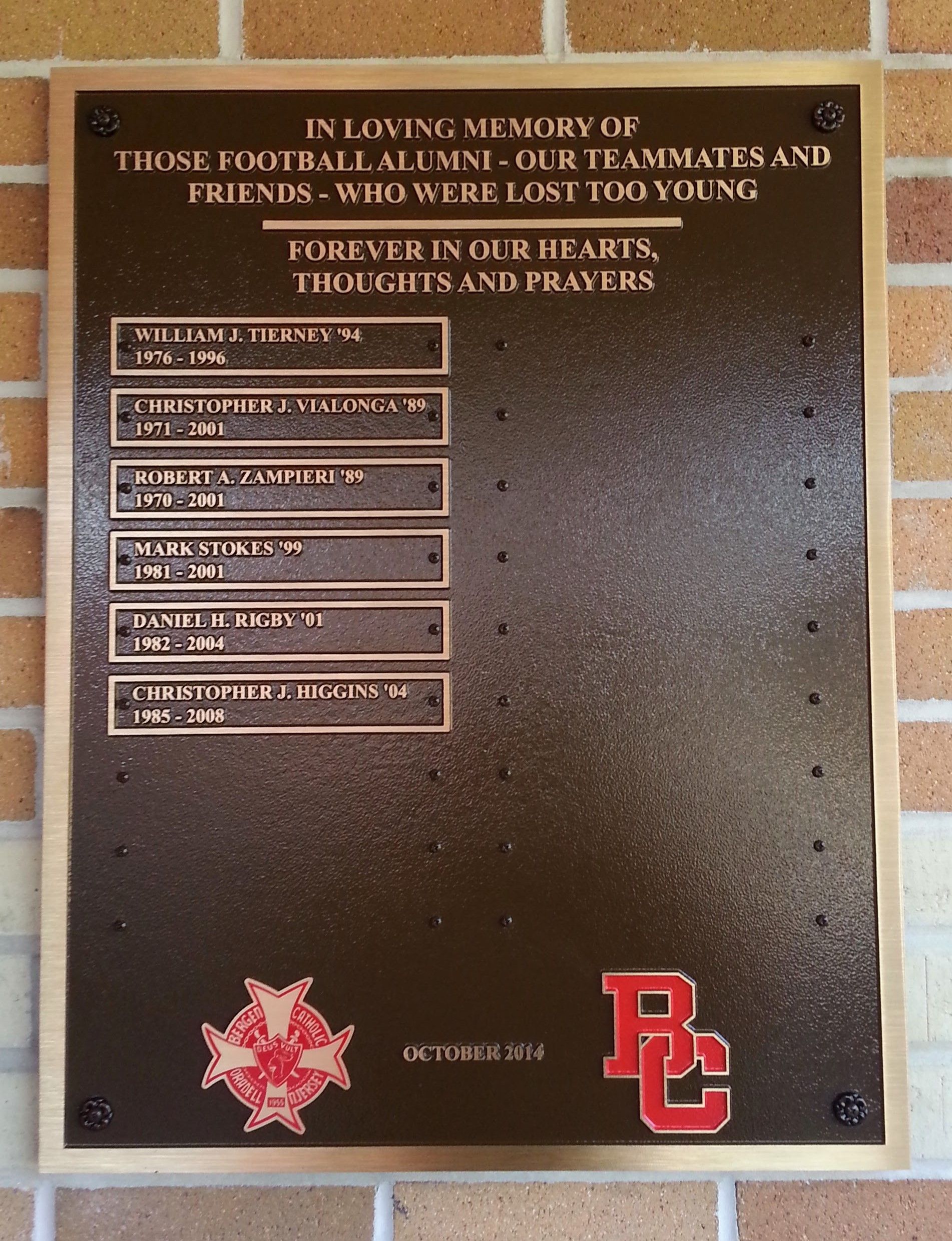 Bronze memorial plaque on brick wall