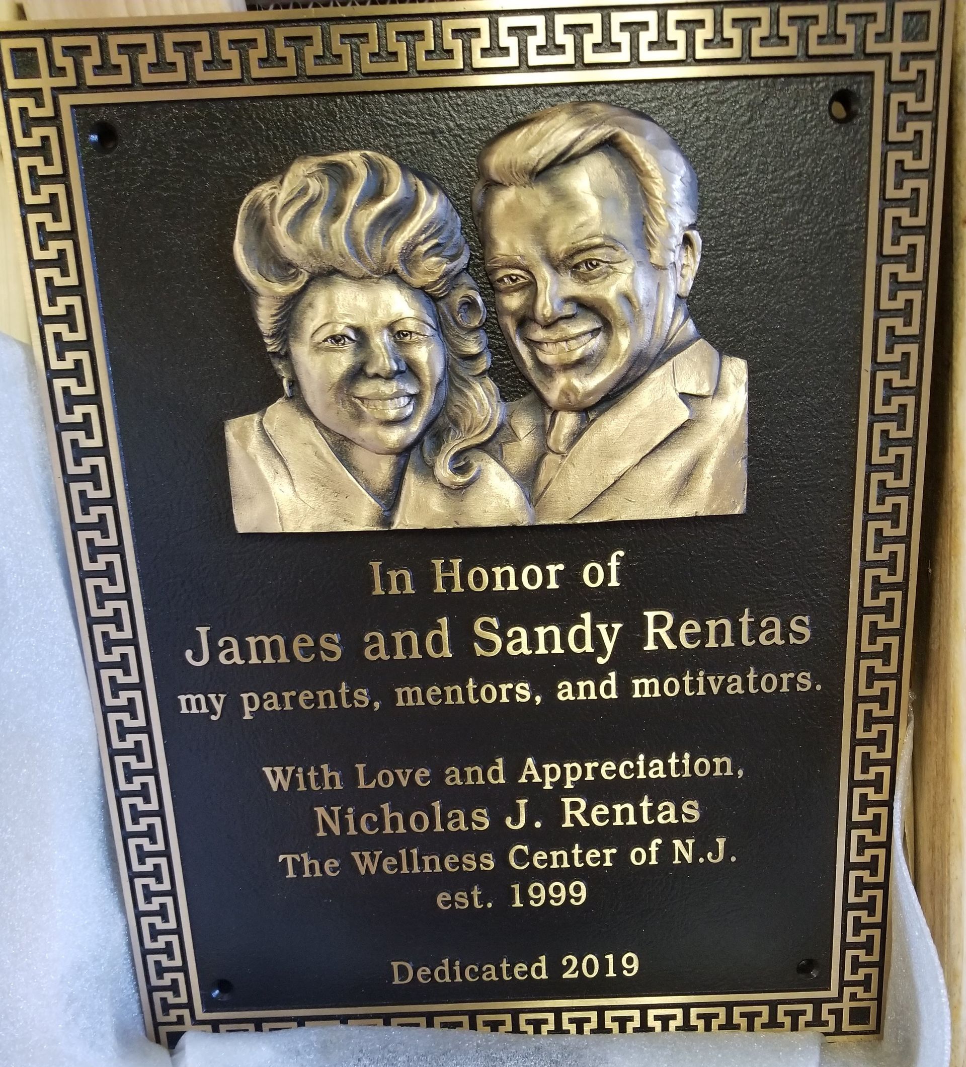 Bronze plaque honoring James and Sandy Rentas, with relief portraits and inscription from Nicholas J. Rentas