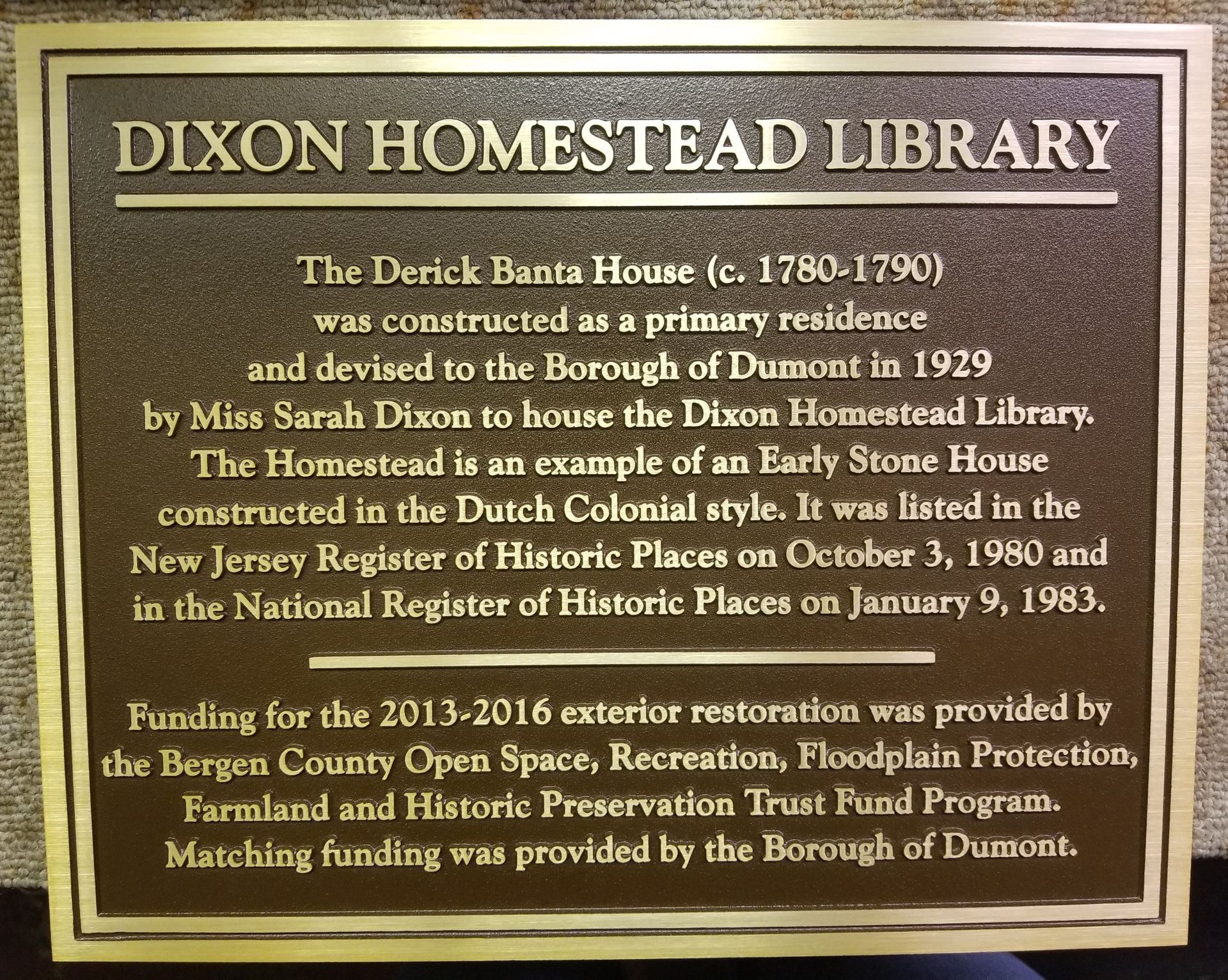 Bronze plaque: Dixon Homestead Library details, including history of the Derick Banta House and restoration funding information