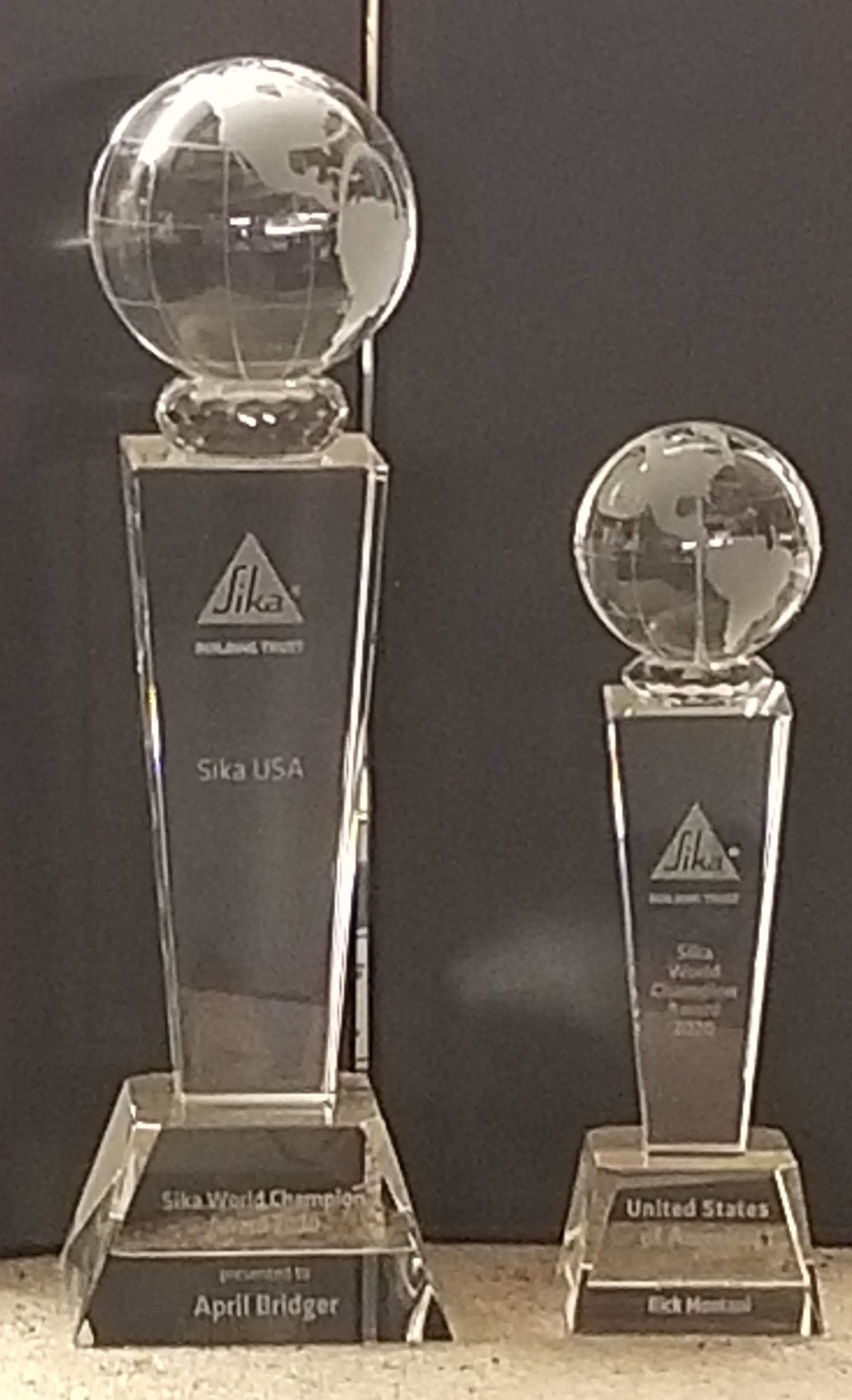 Two glass globe trophies on pedestals