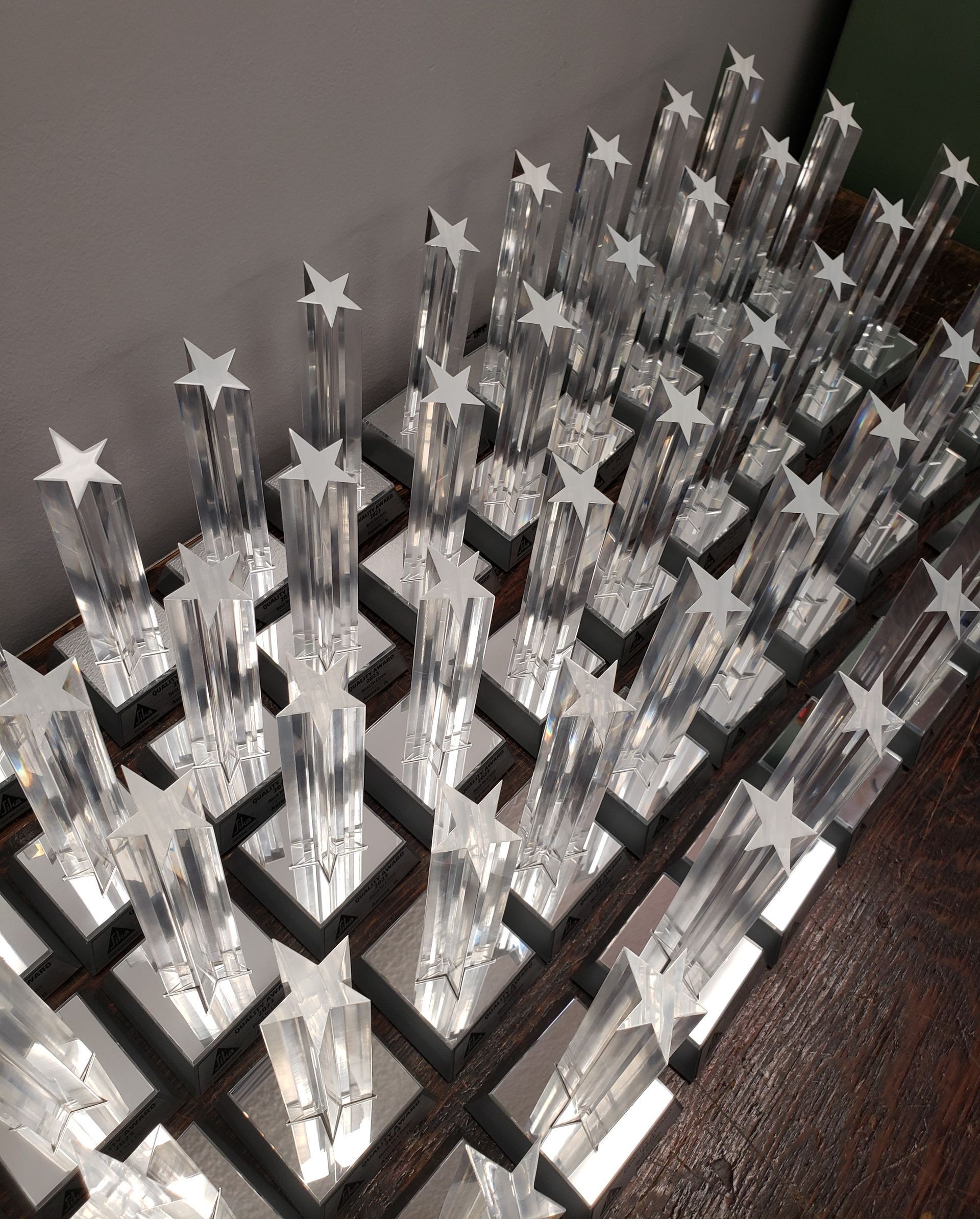 Rows of clear, star-topped trophies on mirrored bases