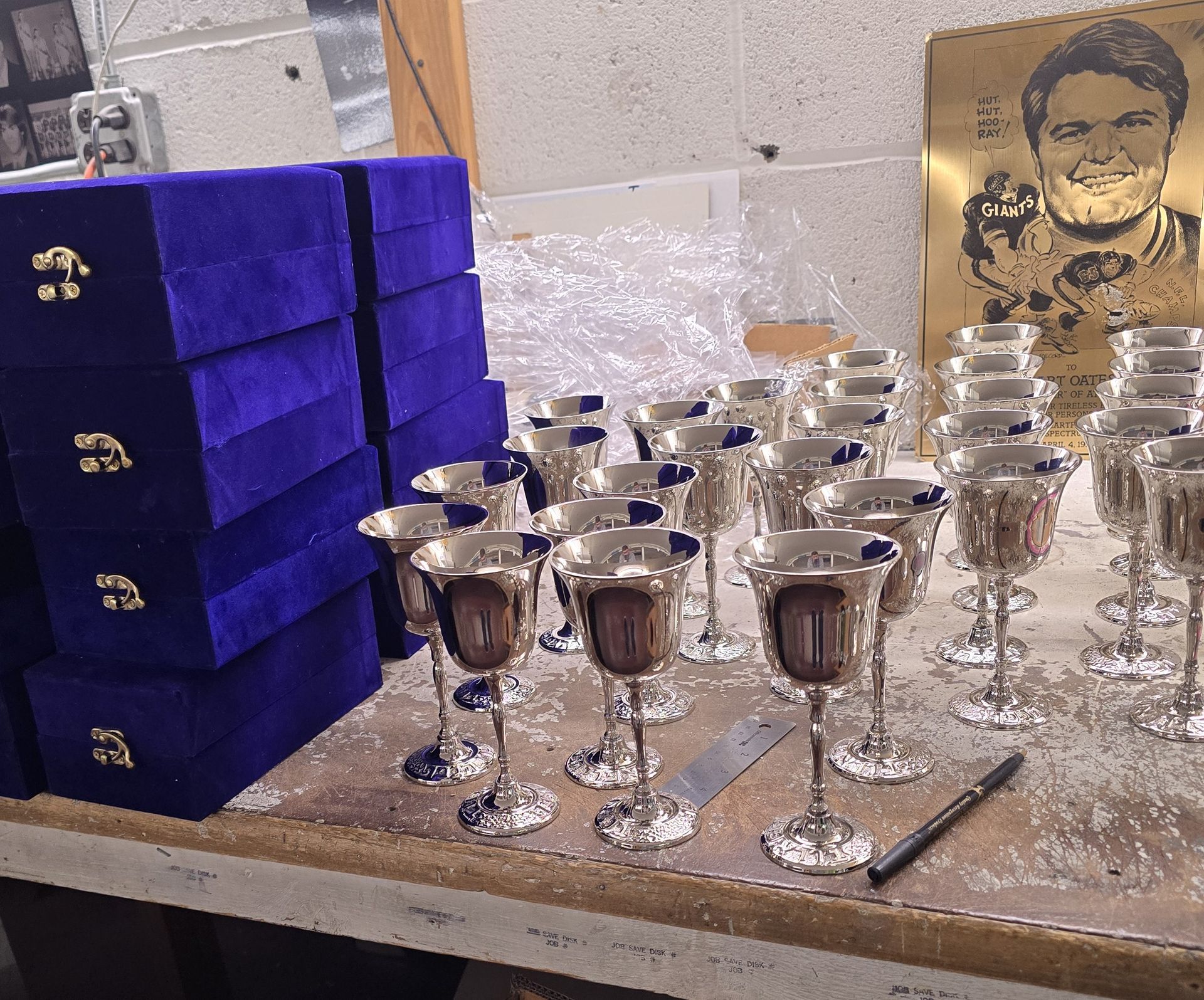 Silver goblets on a table, stacked blue velvet boxes