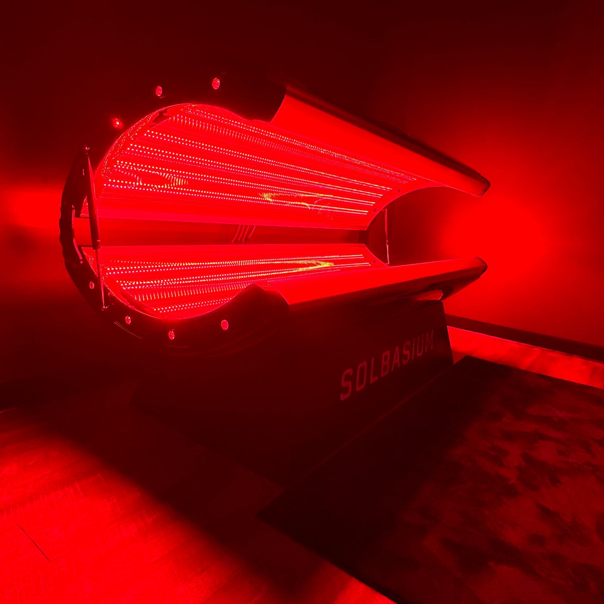 Red LED-lit futuristic lamp glowing on a dark surface in a dim room