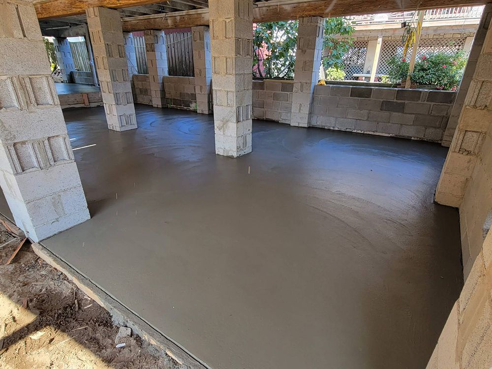 A concrete floor is being poured in a building under construction.