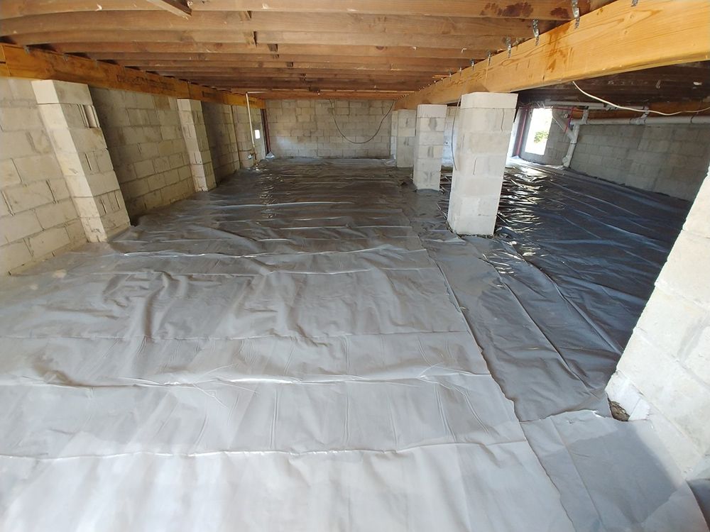 A basement with a lot of plastic on the floor.