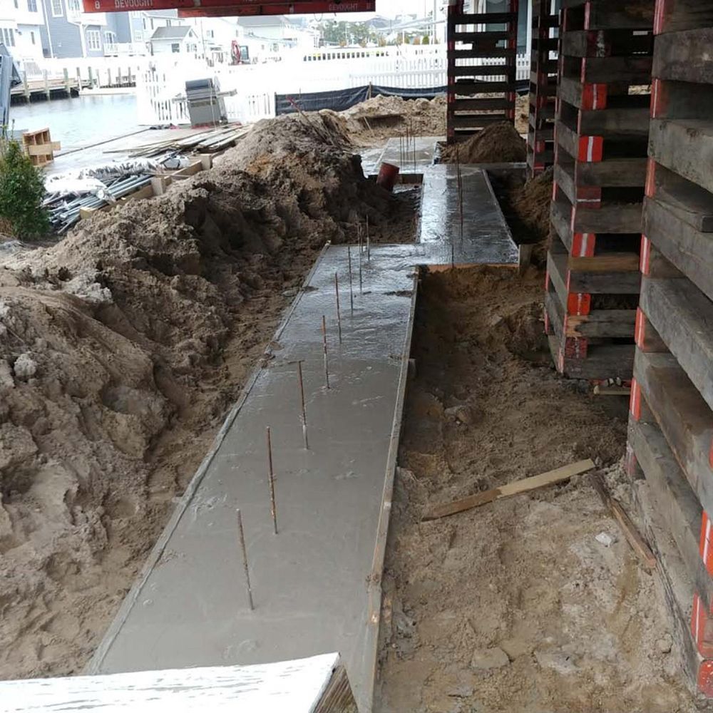 A concrete walkway is being built in the dirt