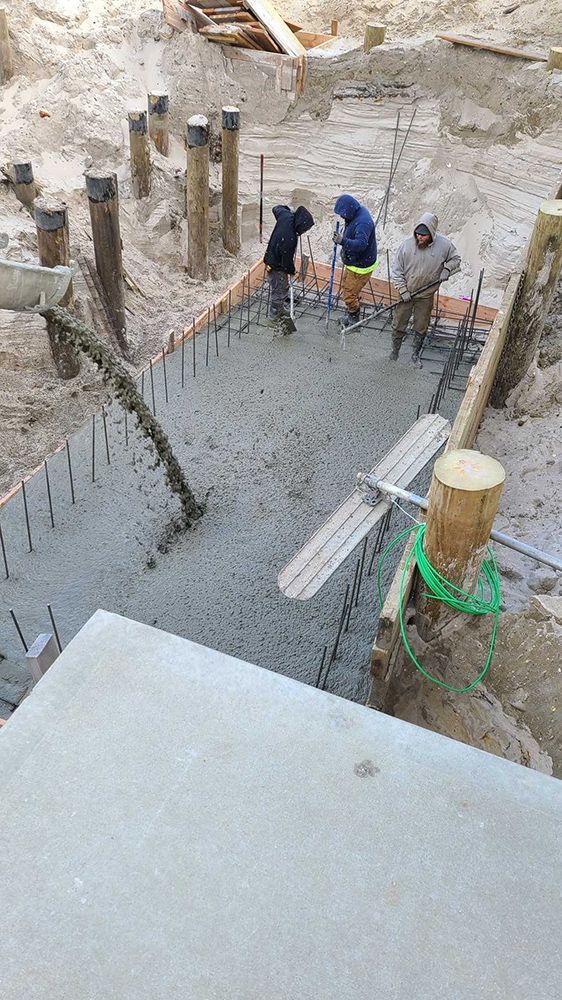 A group of construction workers are working on a concrete floor.
