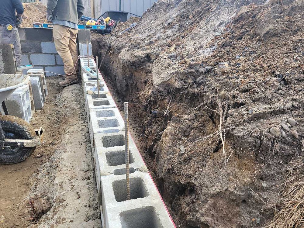 A group of construction workers are working on a concrete wall.